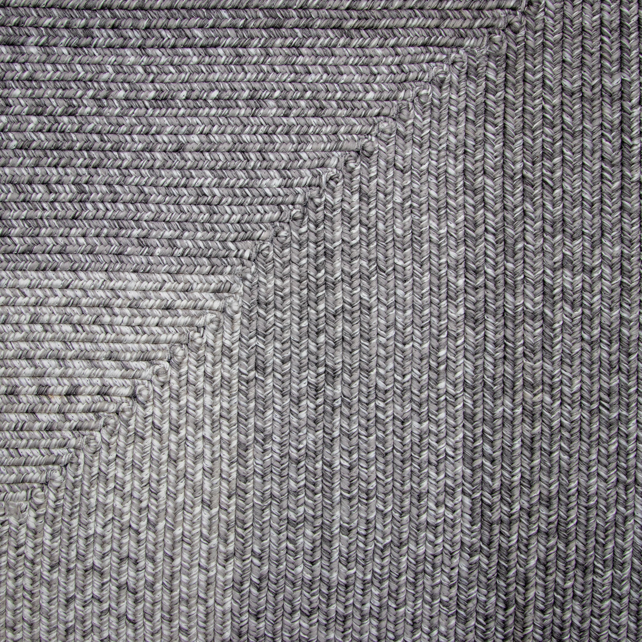 A close-up of the Hestia 220cm x 160cm Weatherproof Indoor and Outdoor Rug in Walnut Grey reveals its textured, woven fabric featuring a diagonal, striped pattern that is UV-resistant for long-lasting durability.