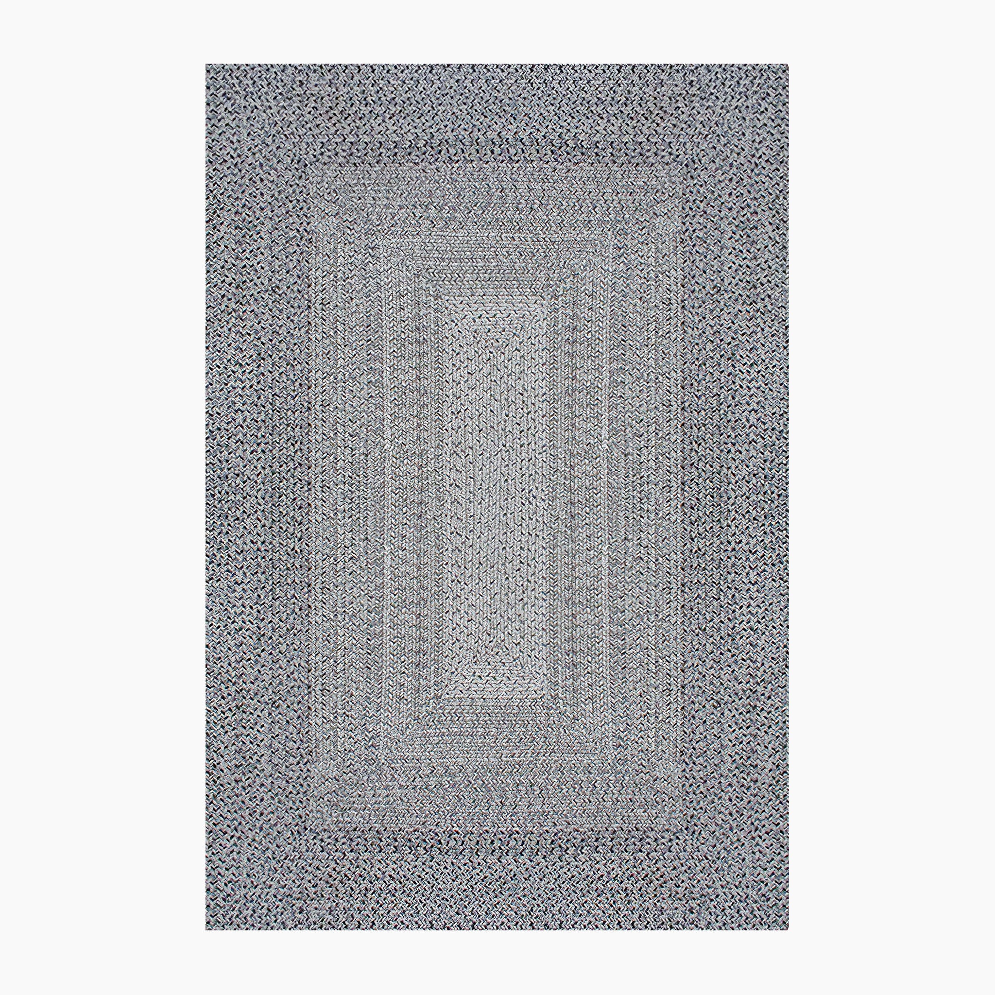 The Hestia 220cm x 160cm Weatherproof Indoor and Outdoor Rug in Walnut Grey features a rectangular braided design with a pattern of concentric rectangles in grey, blue, and white, and is UV-resistant.