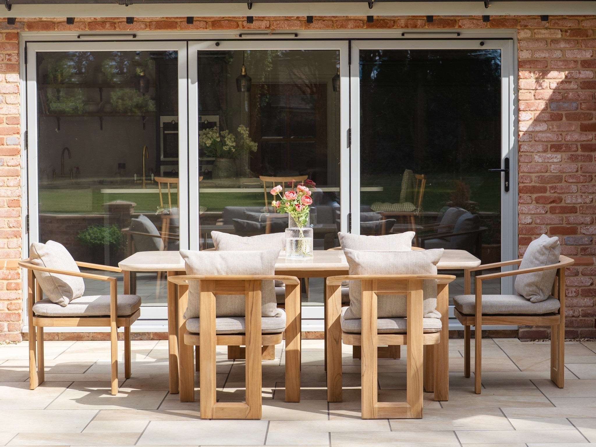 A 6 seat wooden tivoli dining set in front of glass patio doors