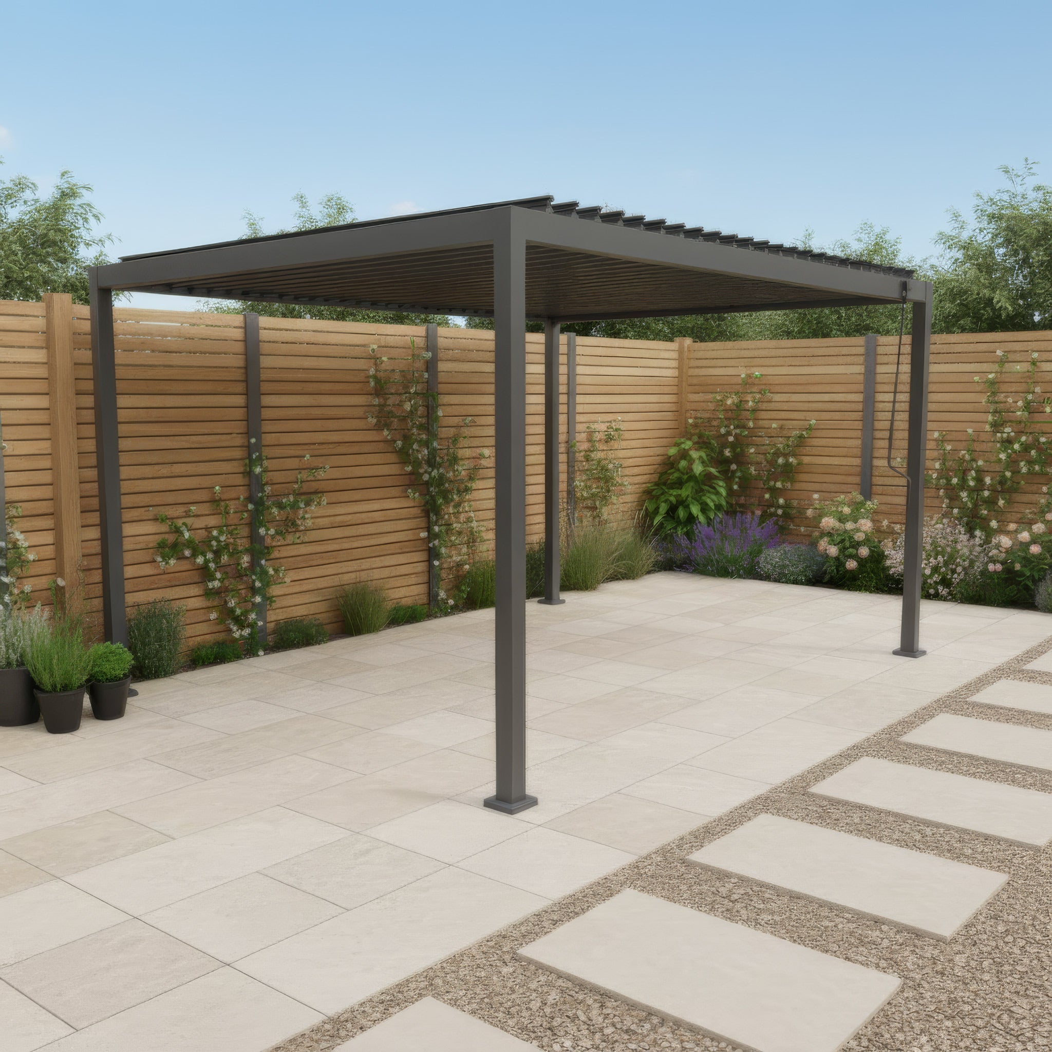 Modern outdoor seating area with grey sofa set under a pergola, next to a brick house with large glass doors.