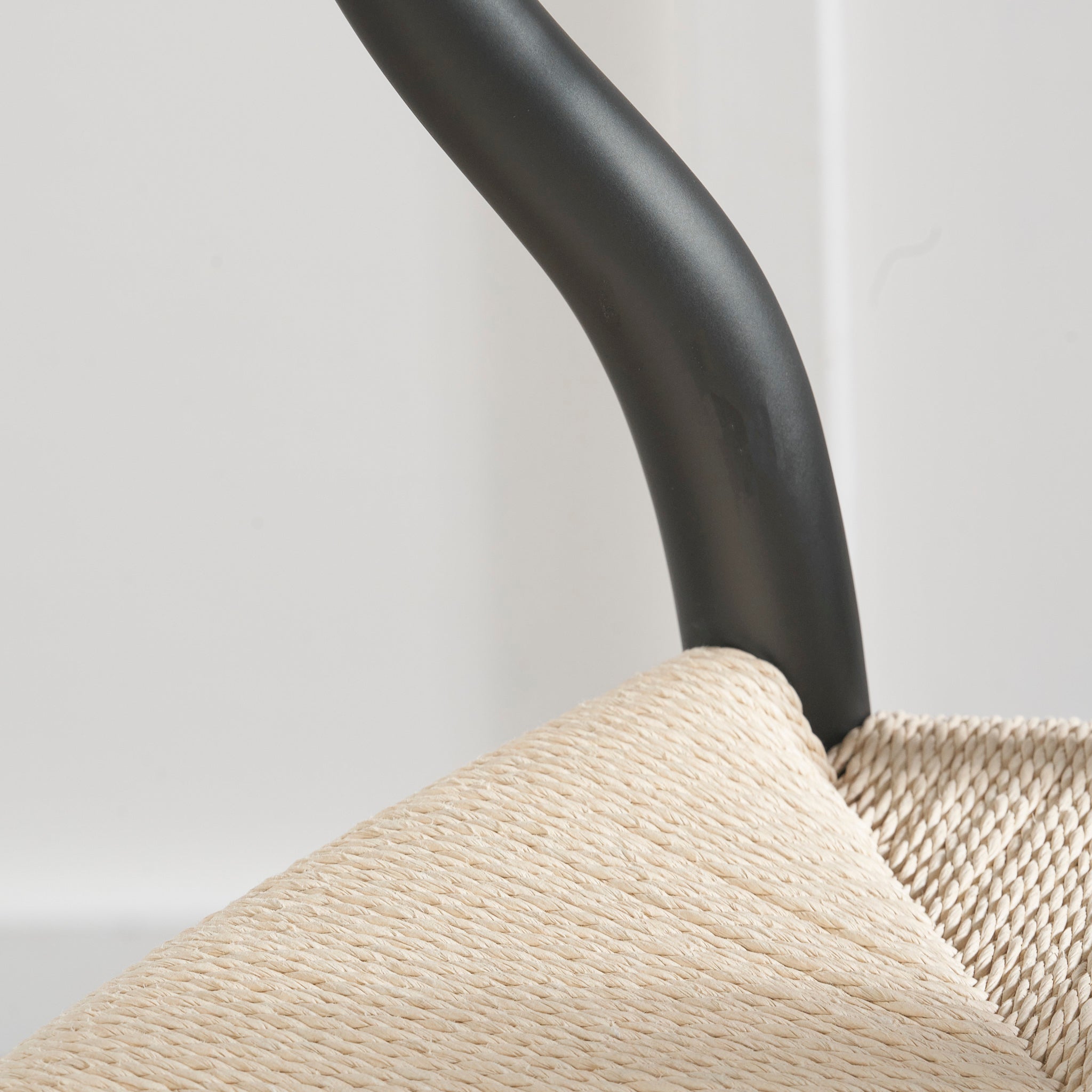 The Pacific Lifestyle - Quinn Dining Chair combines a black curved backrest and natural woven rope seat for an artisanal feel. Its beech wood frame ensures durability, providing timeless elegance and style to any dining space.
