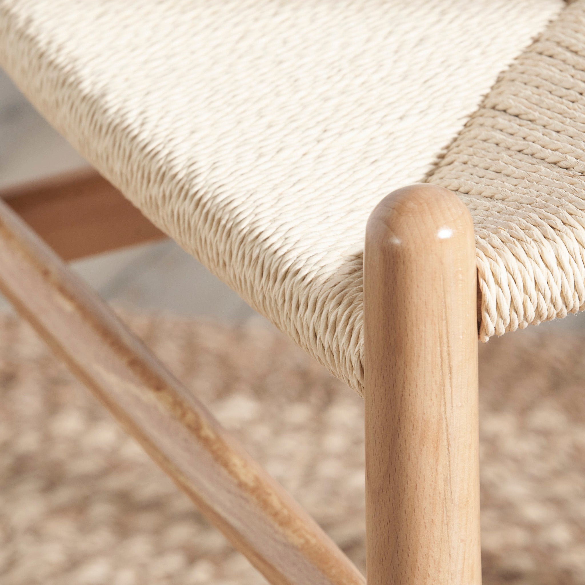 Close-up of a Pacific Lifestyle - Quinn Dining Chair, showcasing its woven natural rope seat, sturdy wooden frame, and smooth natural beech wood legs.
