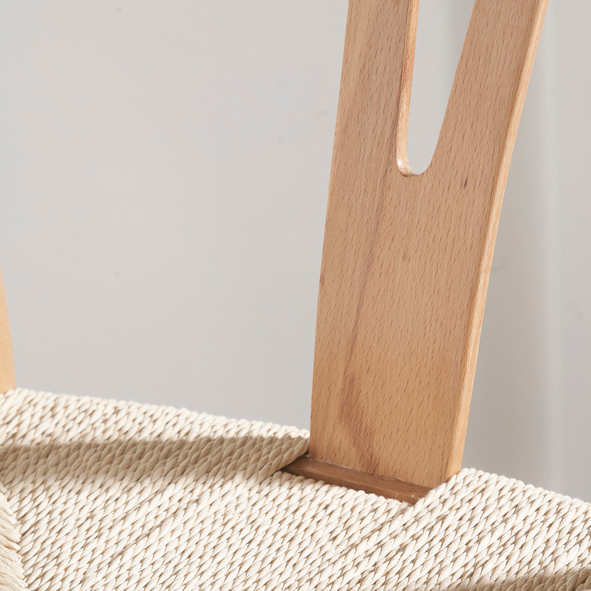 The Pacific Lifestyle Quinn Dining Chair showcases its natural beech wood backrest and elegantly woven natural rope seat in a well-lit setting.