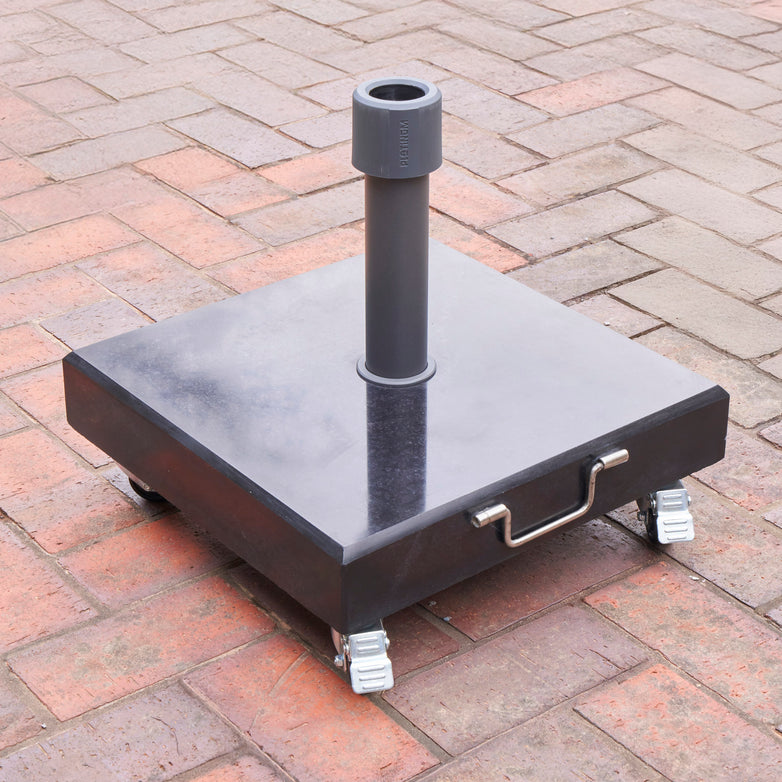 The Pacific Lifestyle Rome Polished Black Granite 40KG Parasol Base, featuring wheels and a handle, is perfect for use with Riva Round Parasol Models or other granite bases on brick-paved surfaces.