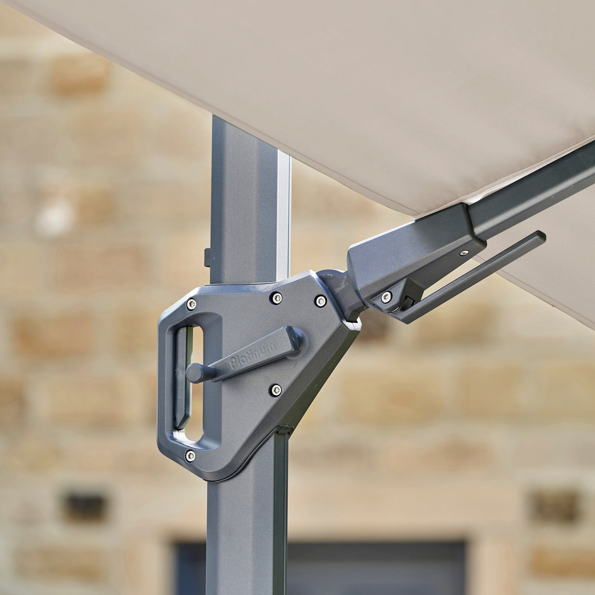 Close-up of the Challenger T2 Premium 3.5m x 2.6m Rectangular Cantilever Parasol crank handle on a metal pole, with a champagne canopy above.