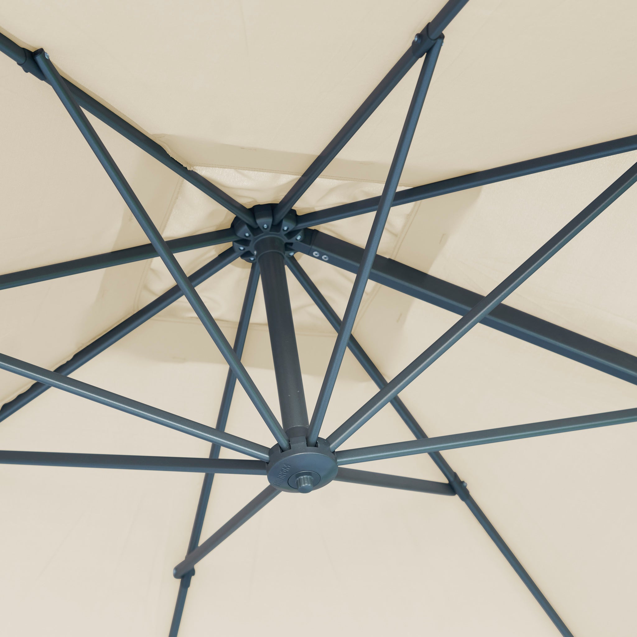 Close-up view of the black metal frame and spokes of the Voyager T2 2.7m Square Cantilever Parasol in Champagne, seen from underneath, offering both style and UV protection for your patio.