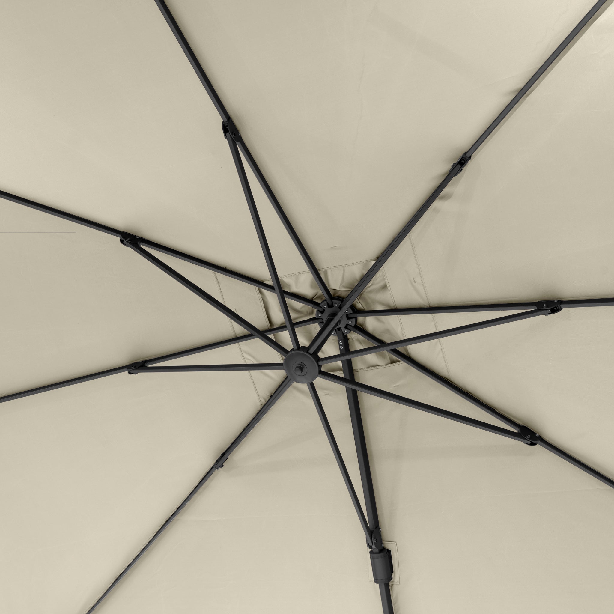 View from beneath a Challenger T2 3.5m x 2.6m Rectangular Cantilever Parasol in Champagne, highlighting metal spokes radiating from the center hub—an elegant shade solution with 360-degree rotation for versatile outdoor coverage.