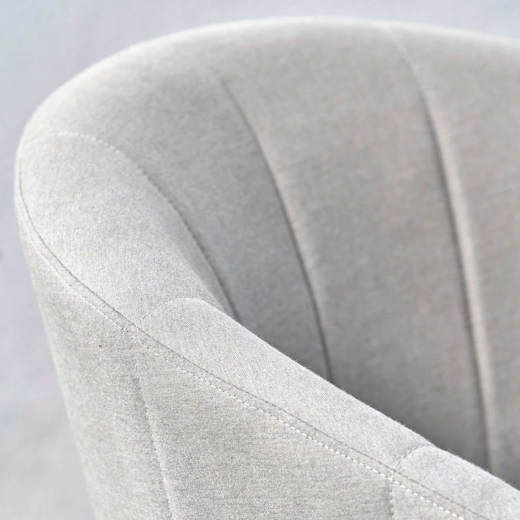 Close-up of a light gray upholstered chair with a curved backrest and visible stitching details, perfectly complementing the Kai 4 Seat Round Dining Set in Light Grey.