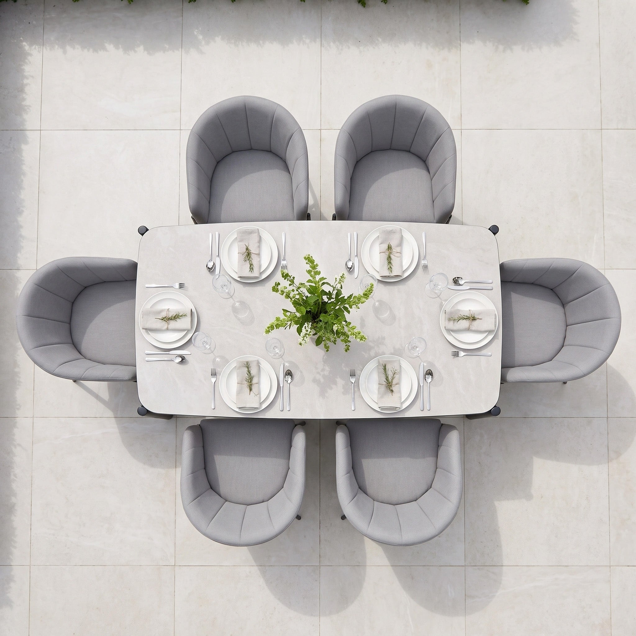 Introducing the Kai 6 Seat Rectangular Dining Set in Light Grey—an elegant choice for outdoor gatherings. Crafted with a powder-coated aluminium frame, this stylish garden dining set comes complete with neutral plates, glassware, and a lush green centerpiece, making it perfect for chic alfresco meals.