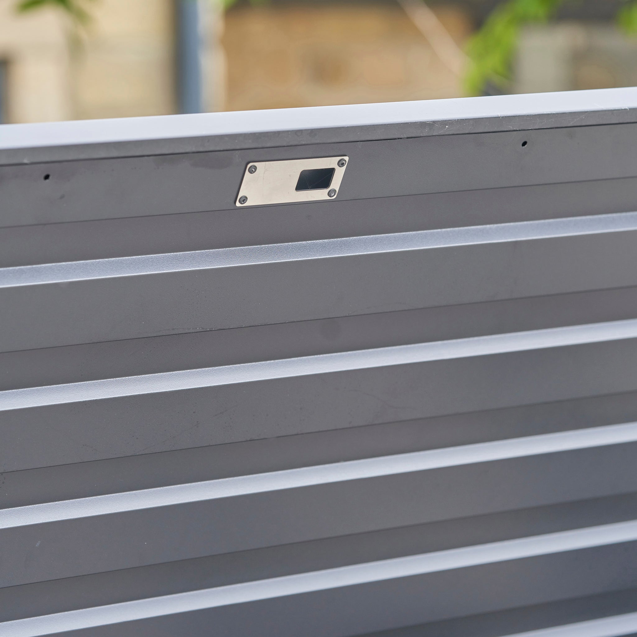 Close-up of the Pacific Lifestyle Rhode Island Large Outdoor Cushion Box in Anthracite, featuring a rectangular keyhole plate near the top.