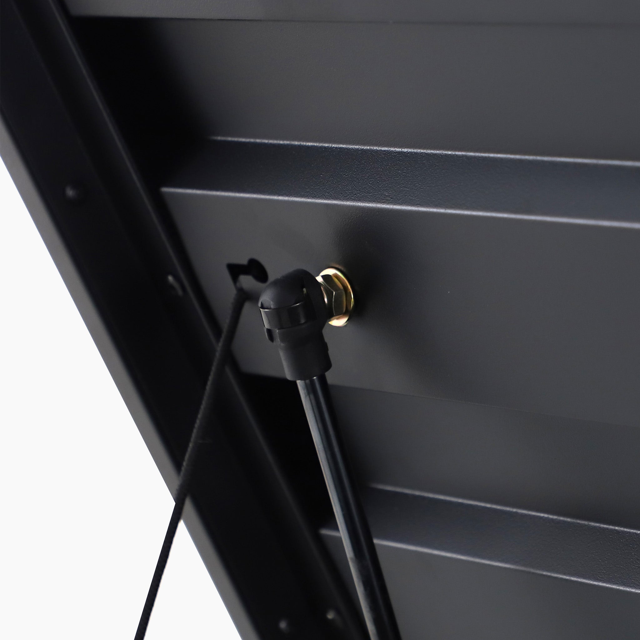 Close-up of a black metal panel from the Pacific Lifestyle - Rhode Island Large Outdoor Cushion Box, featuring a cable and gold-colored connector.