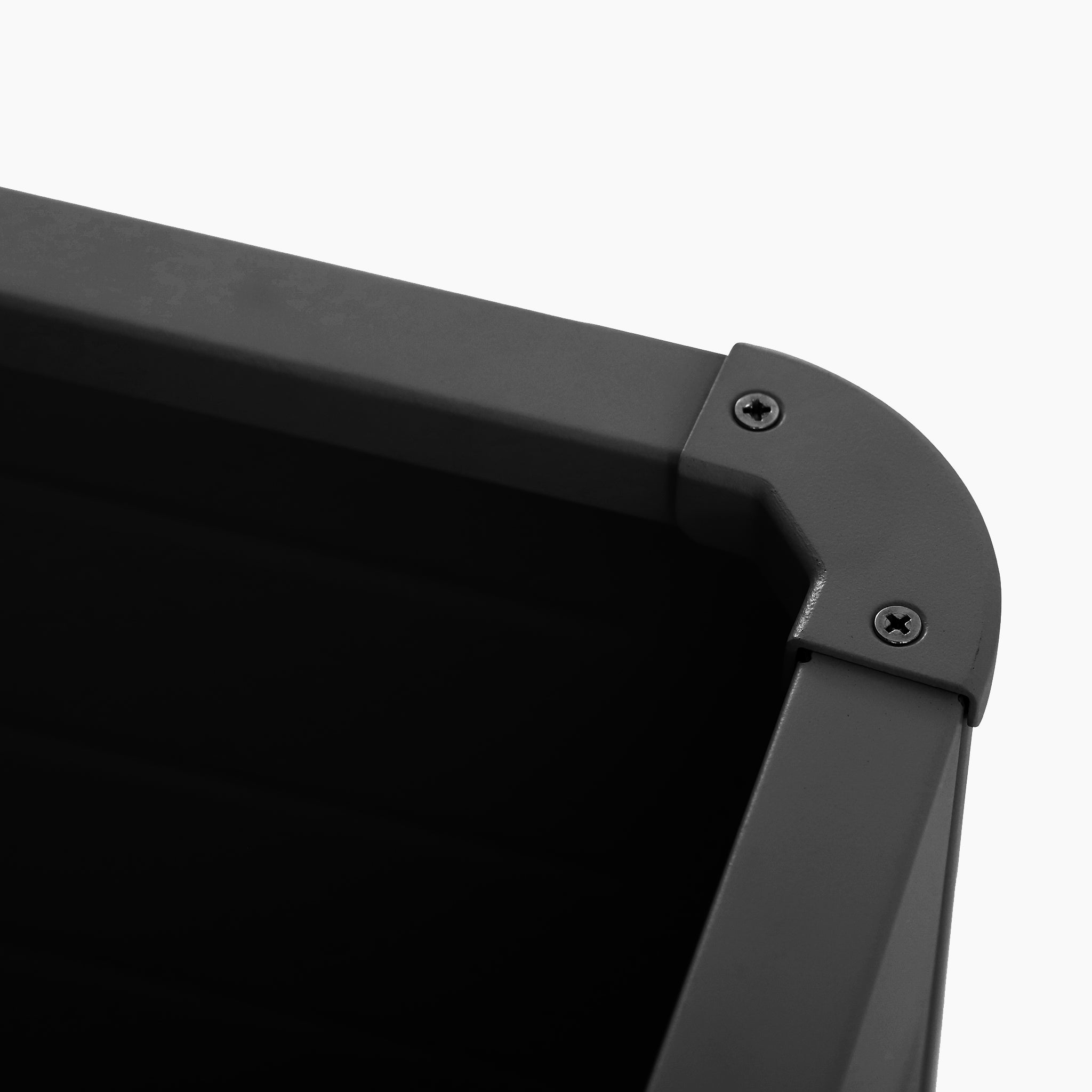 Close-up of the corner of the Pacific Lifestyle - Rhode Island Small Outdoor Cushion Box in Black, showing two screws against a white background.
