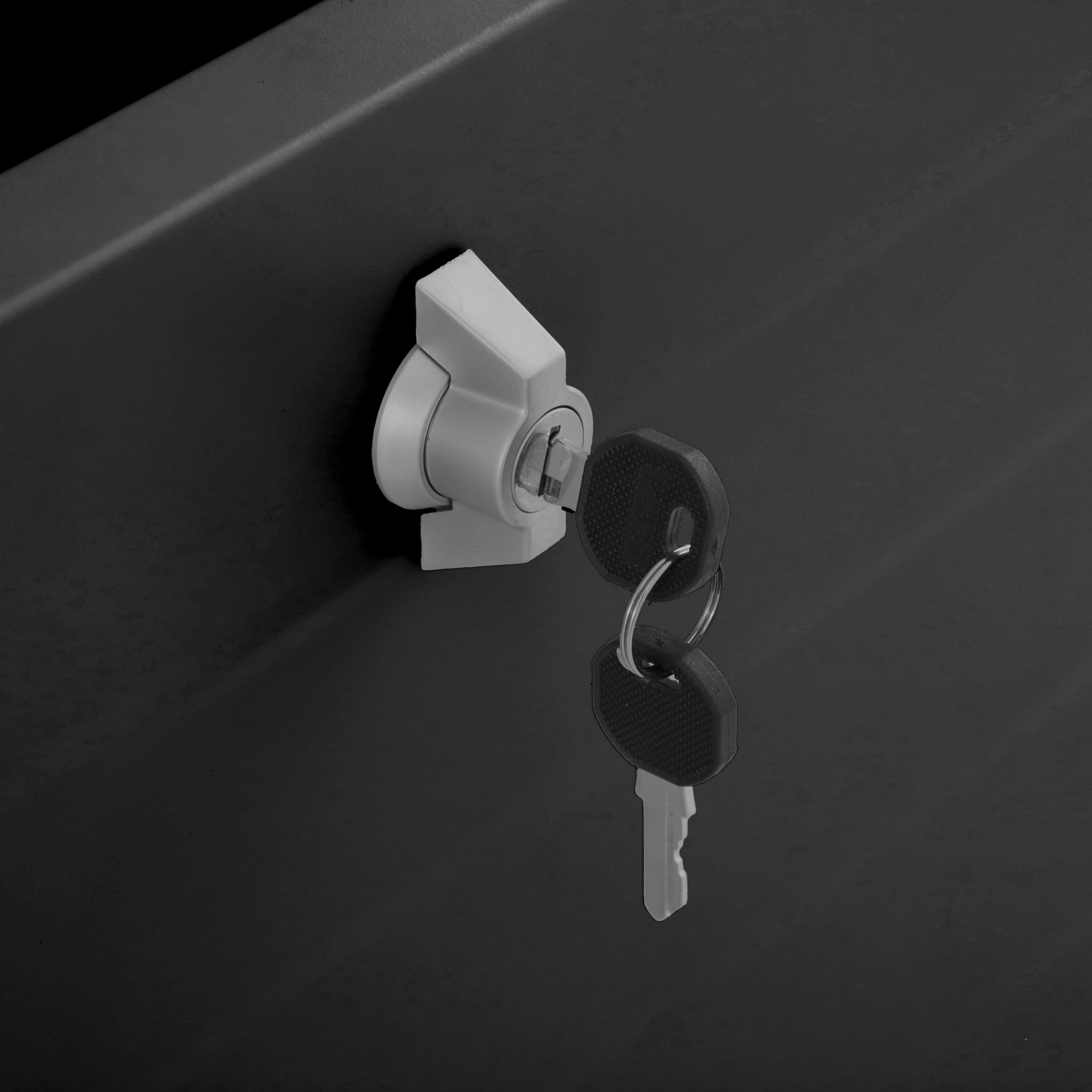 A close-up of the secure lock and keys highlights the safety features of the Pacific Lifestyle - Rhode Island Small Outdoor Cushion Box in Black.