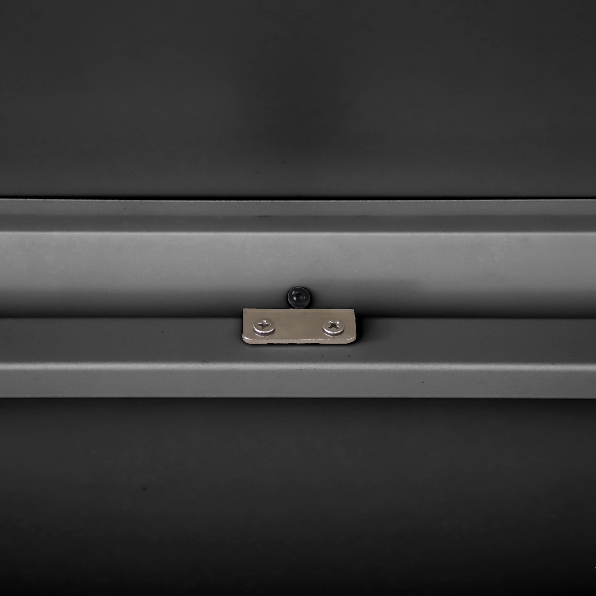 A Pacific Lifestyle Rhode Island Small Outdoor Cushion Box in black is placed on a flat, dark gray surface.
