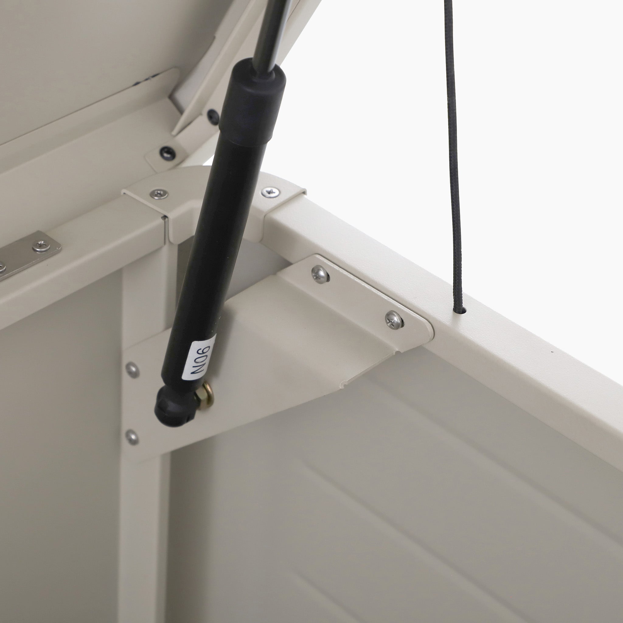 Close-up of a black gas strut on the hinge inside a light Pebble Pacific Lifestyle Rhode Island Large Outdoor Cushion Box, an ideal durable option for outdoor storage.