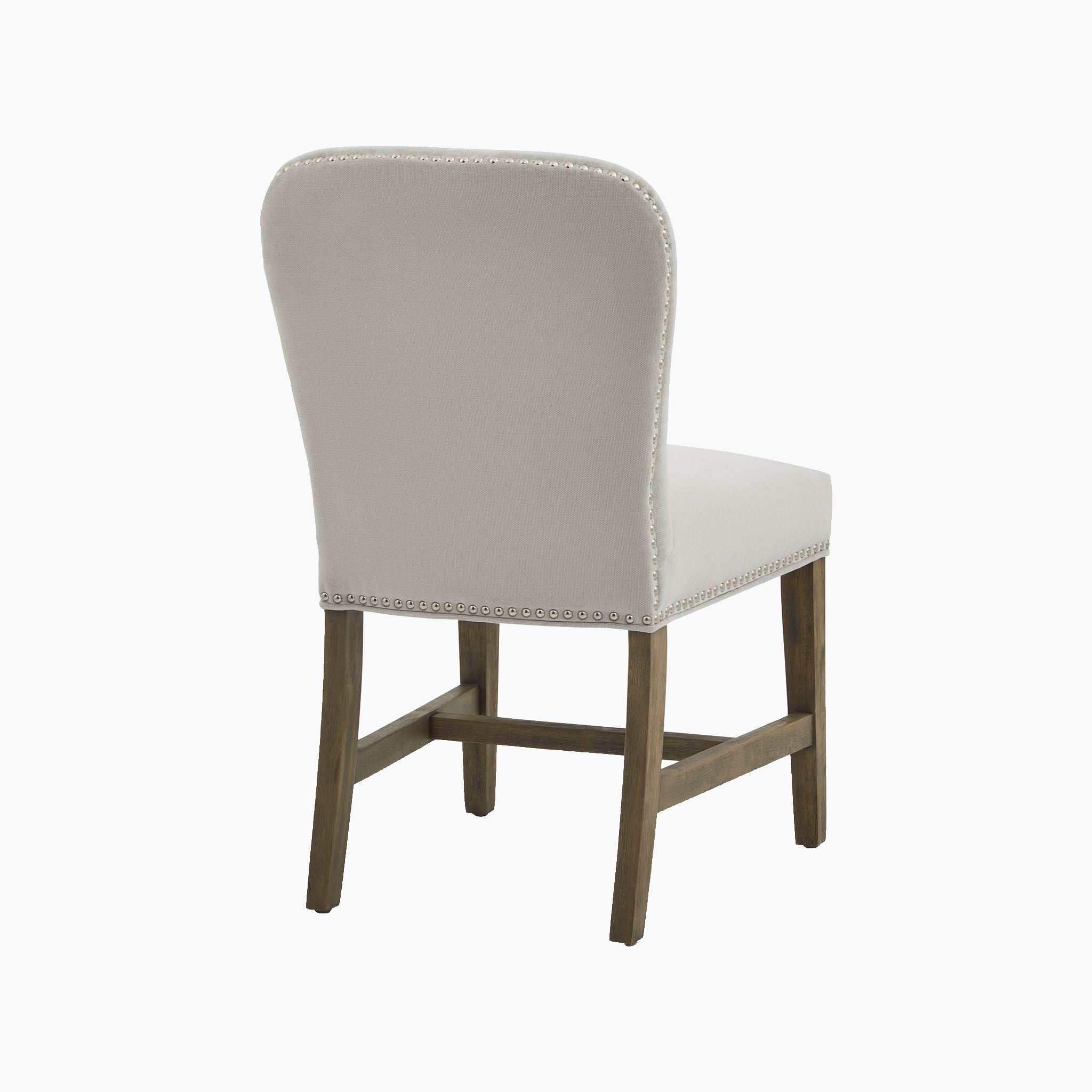The Cobham Grey Dining Chair boasts elegant grey upholstery and traditional French design, highlighting its wooden frame and stud accents from the rear.