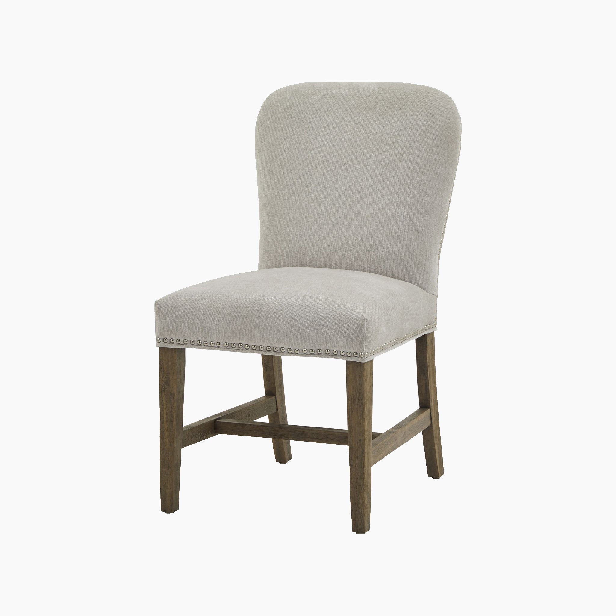 The Cobham Grey Dining Chair boasts timeless French design, featuring plush grey upholstery, wooden legs, and elegant nailhead trim.