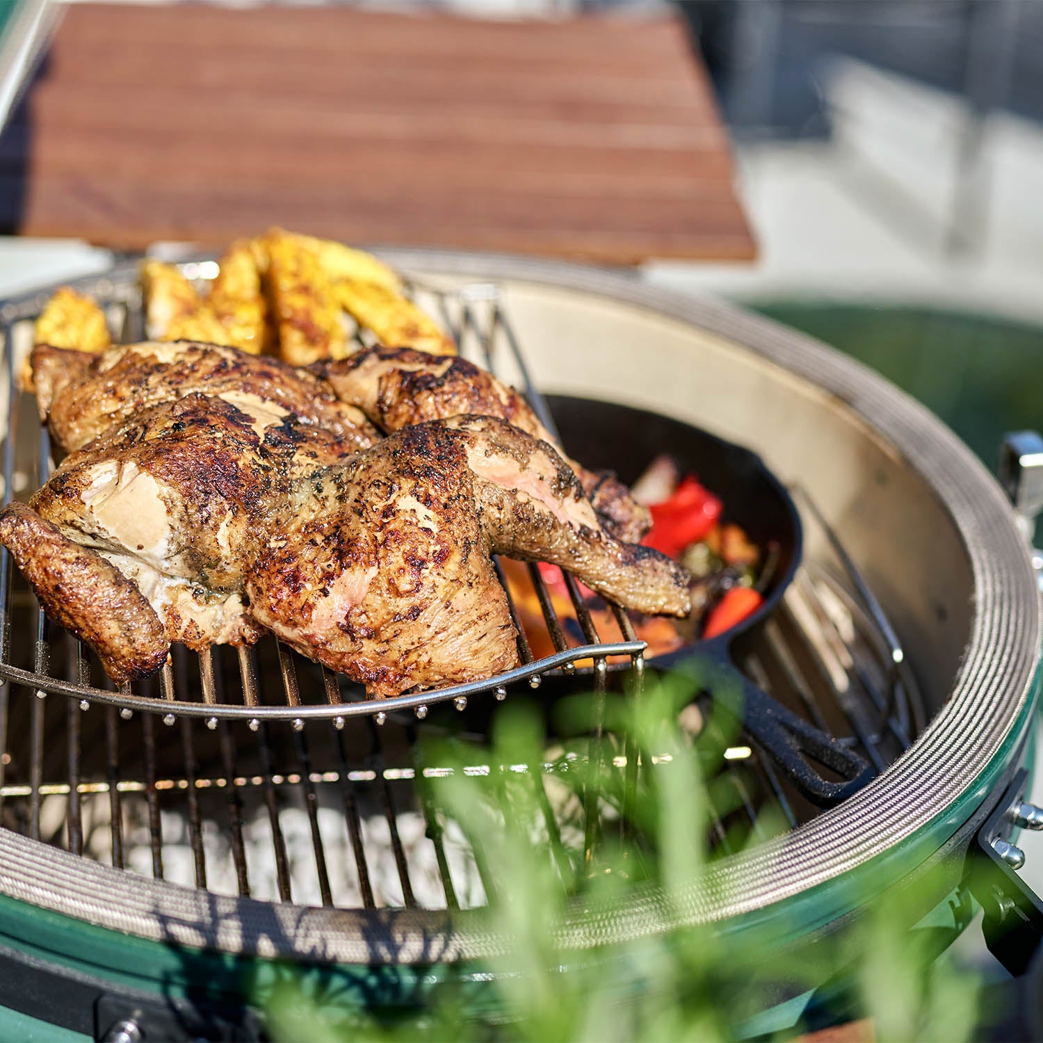 Grilled whole chicken and vegetables cooking on a green Kamado Grill, using the Cooking Grid Expander for 18" Kamado Grills to gain 60% more cooking space.