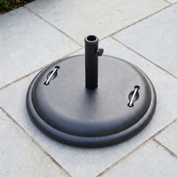 The 25kg Concrete Parasol Base, featuring two handles, sits on light gray outdoor tiles and provides sturdy, reliable support for your umbrella.