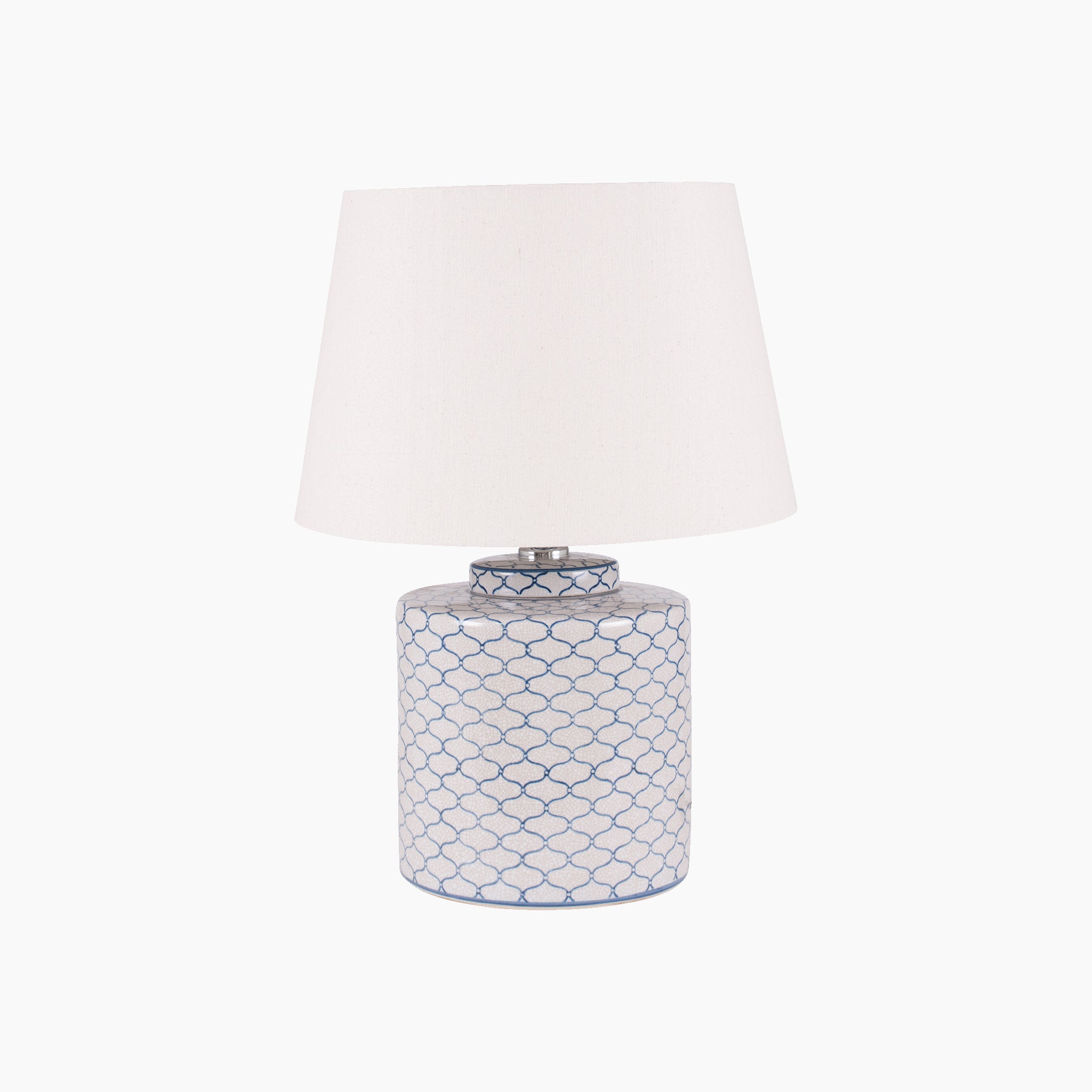 The Pacific Lifestyle Demetri Table Lamp features a ceramic base with a chic blue net pattern and is topped with a white shade, adding geometric allure to any room.
