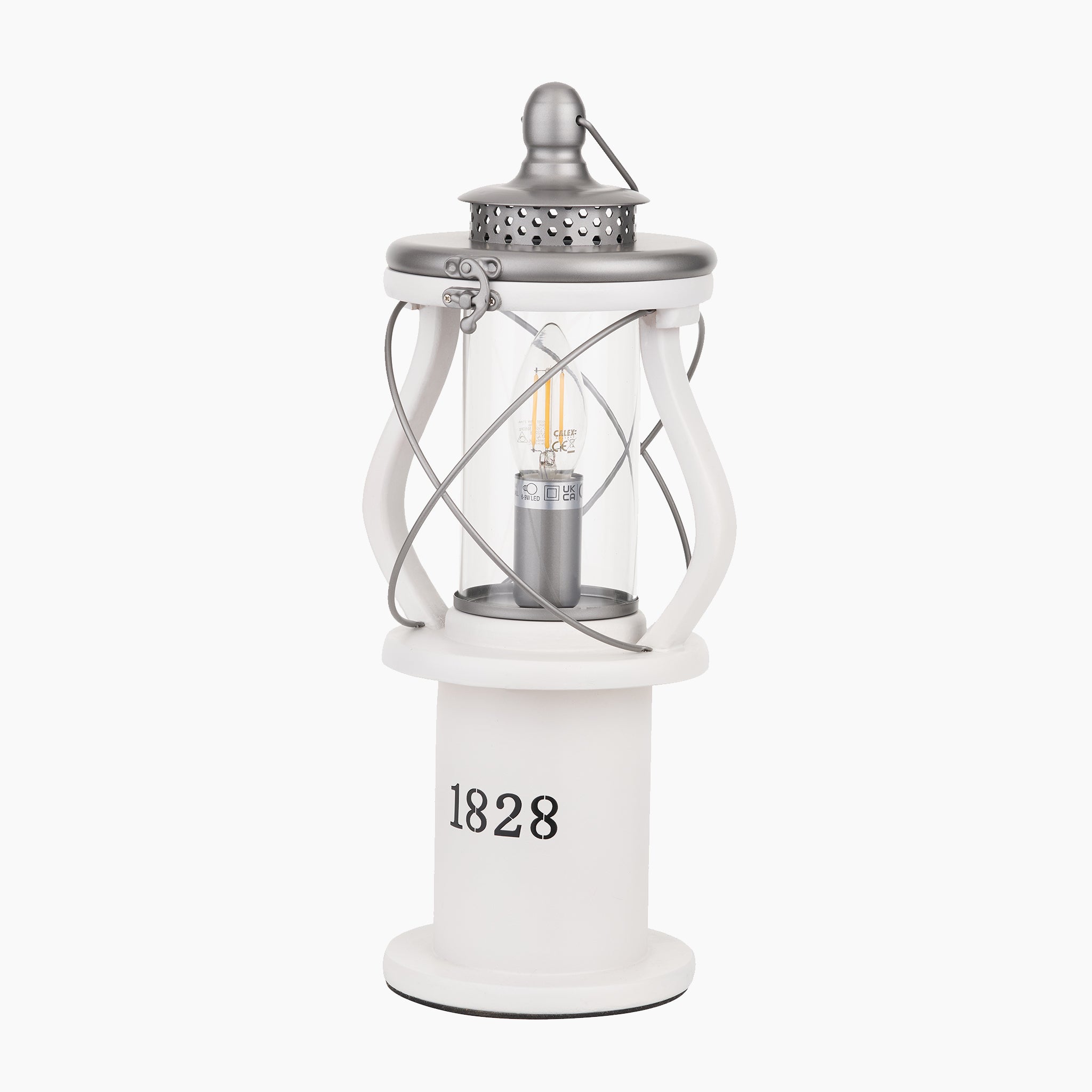 The Pacific Lifestyle Gibson Wood Lantern Table Lamp in white wood features a metal top, clear glass panels, and "1828" on the base—perfect as a decorative table lantern to add antique charm to any space. Shown isolated on a white background.