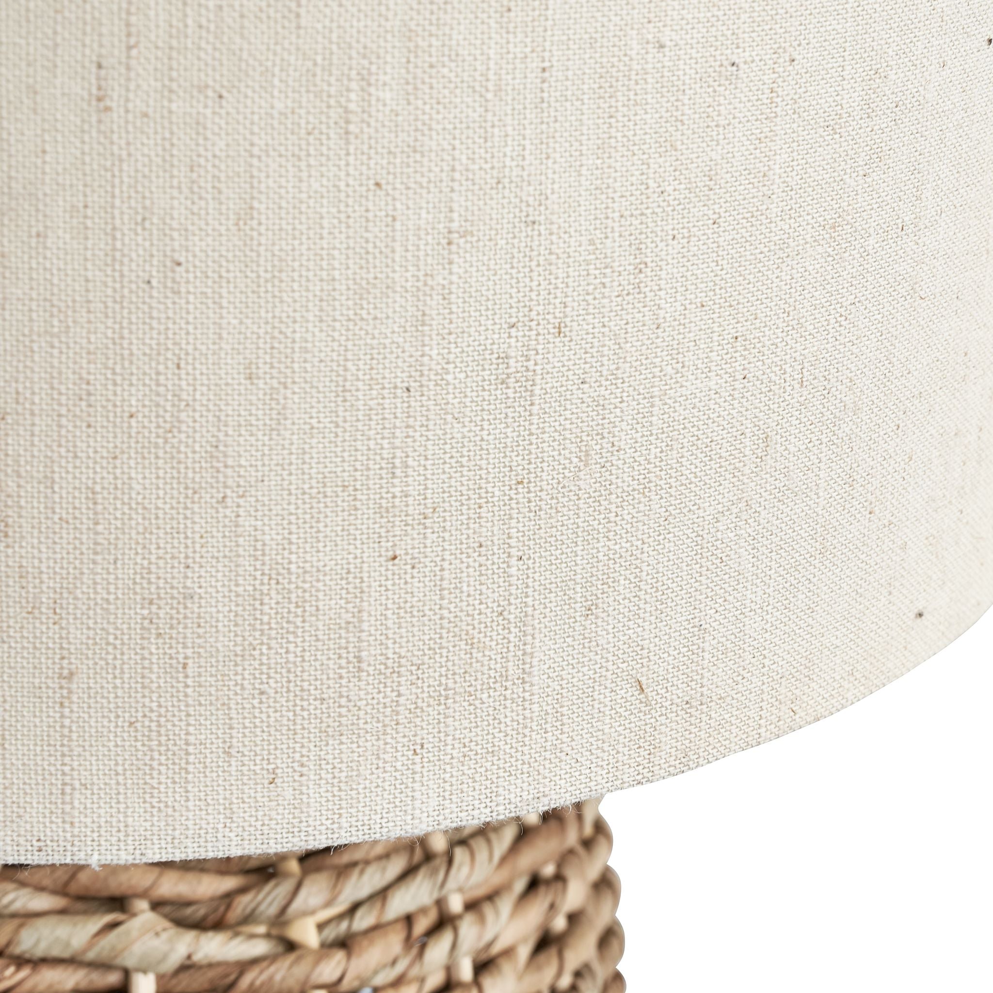 Close-up of a Pacific Lifestyle Acer Natural Woven Tall Table Lamp in ivory, featuring an ivory jute shade and a woven wicker base that exudes neutral tones.