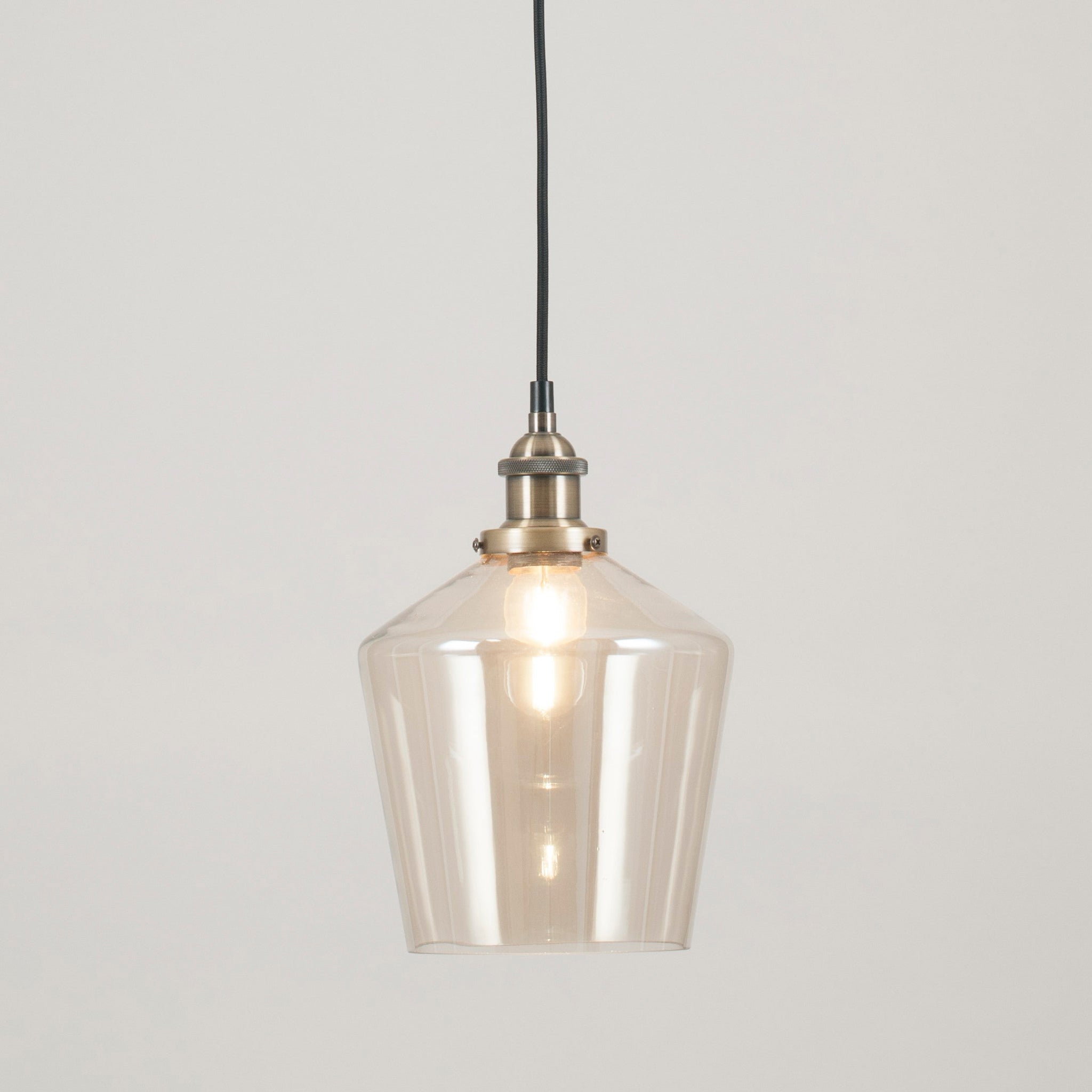 The Pacific Lifestyle - Emmanuelle pendant showcases a clear glass retro cloche shade with a visible bulb, elegantly suspended against a plain white background with an antique brass fitting.