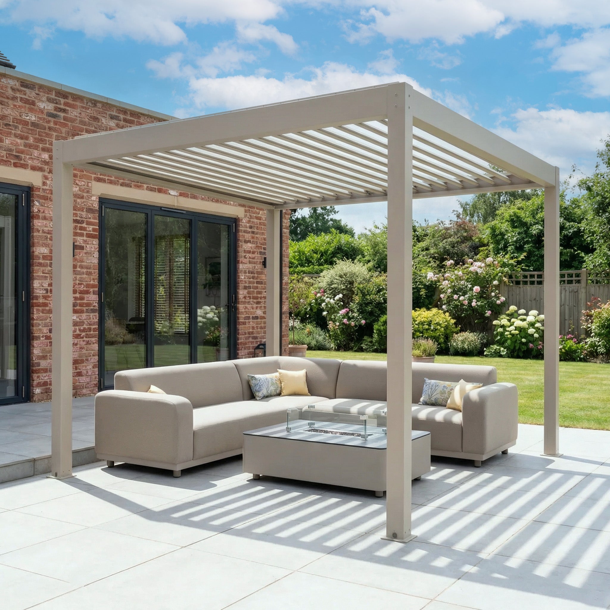 Modern outdoor patio featuring the PergoSTET Plus Frame Only 3m x 3m Square Pergola with LED Lighting in Latte, beige sectional sofas, and a glass coffee table on a sunny day.