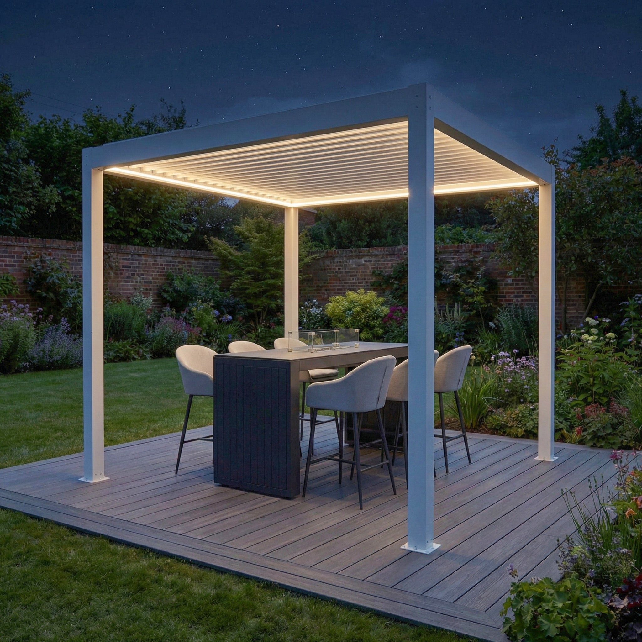 The PergoSTET Plus Frame Only 3m x 3m Square Pergola in White, with LED lighting, shelters a dining set on a wooden patio in a garden at night.