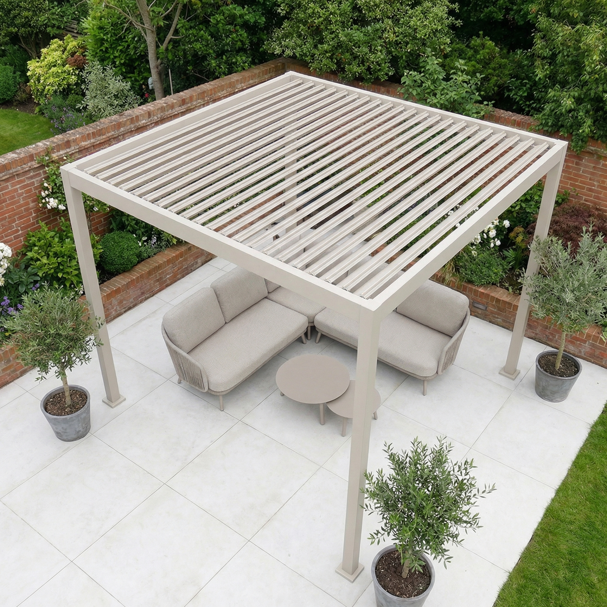 A PergoSTET Lite 3m x 3m Metal Square Pergola in Latte features two sofas and a round table on a tiled patio, surrounded by potted plants and lush greenery.