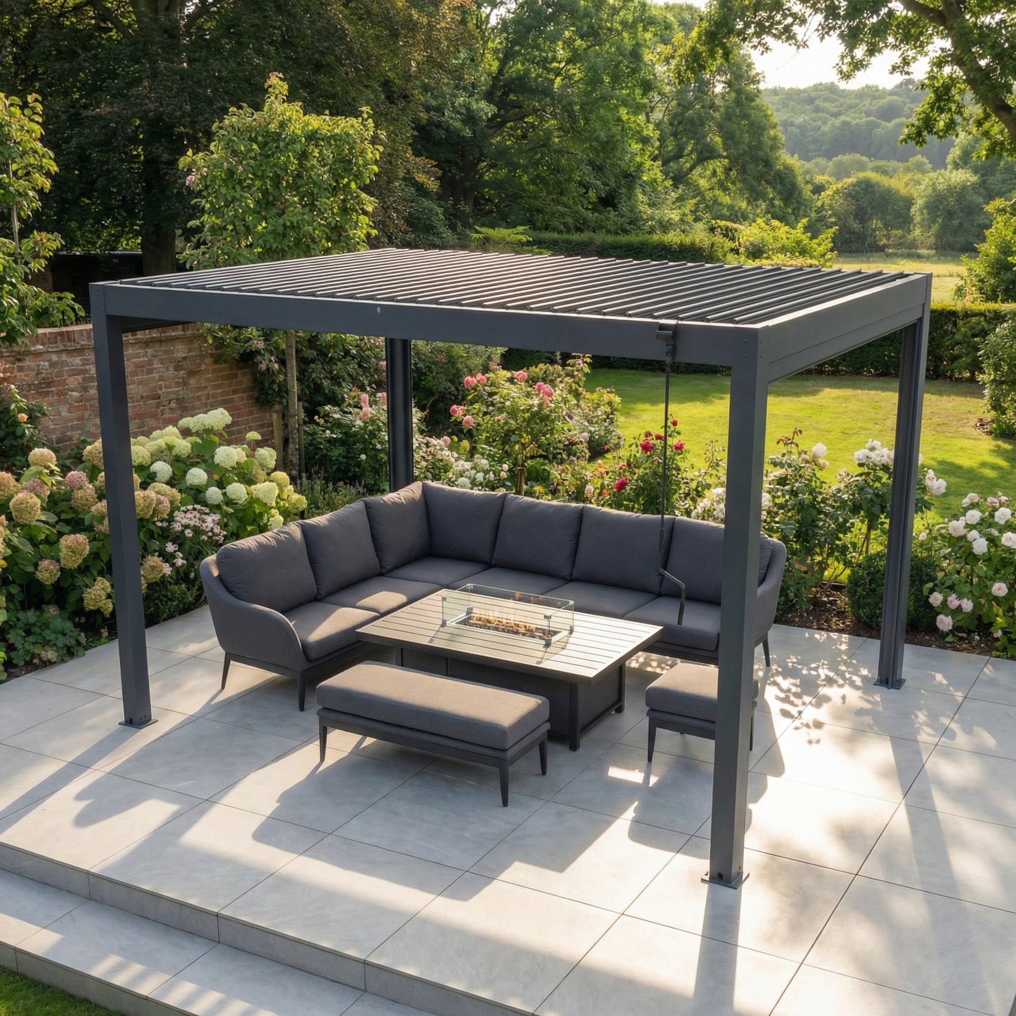 PergoSTET Plus Frame Only 3m x 4m Rectangular Pergola with LED Lighting in Grey creates a modern patio space, paired with a gray outdoor sofa set and table, surrounded by lush garden greenery.