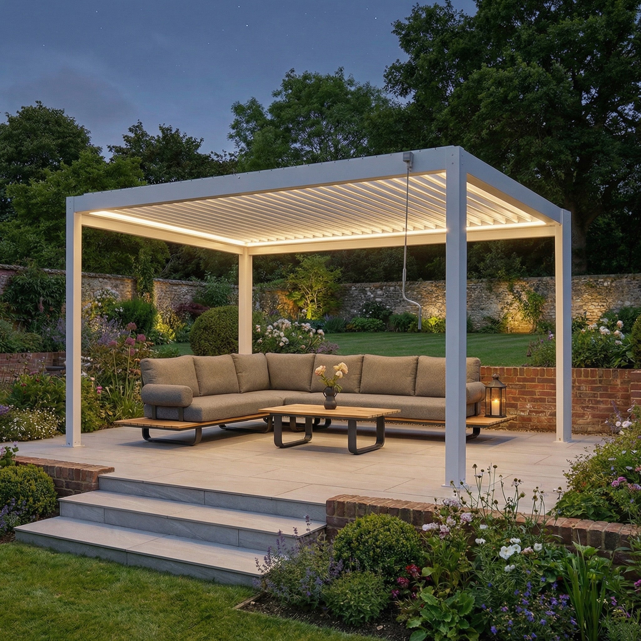 A contemporary patio at dusk features the PergoSTET Plus Frame Only 3m x 4m White Pergola with LED Lighting, complemented by a sectional sofa and garden landscaping.