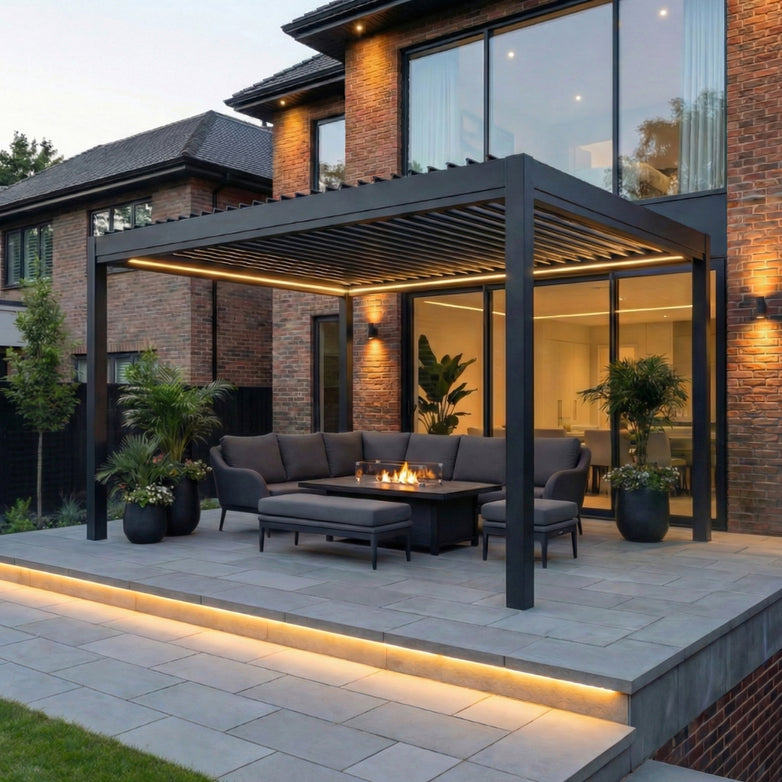 Modern patio with the PergoSTET Pro Frame Only 3m x 4m Rectangular Pergola in Grey featuring LED lighting, a sectional sofa, fire pit table, potted plants, and soft evening ambiance.