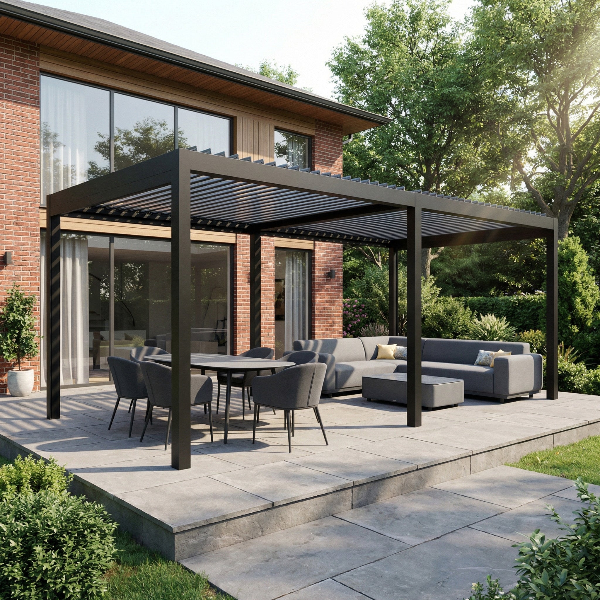 A modern outdoor patio with the PergoSTET Pro Frame Only 3m x 6m Rectangular Pergola in Grey featuring LED lighting, a dining table, and sofa set beside a brick house surrounded by lush greenery.