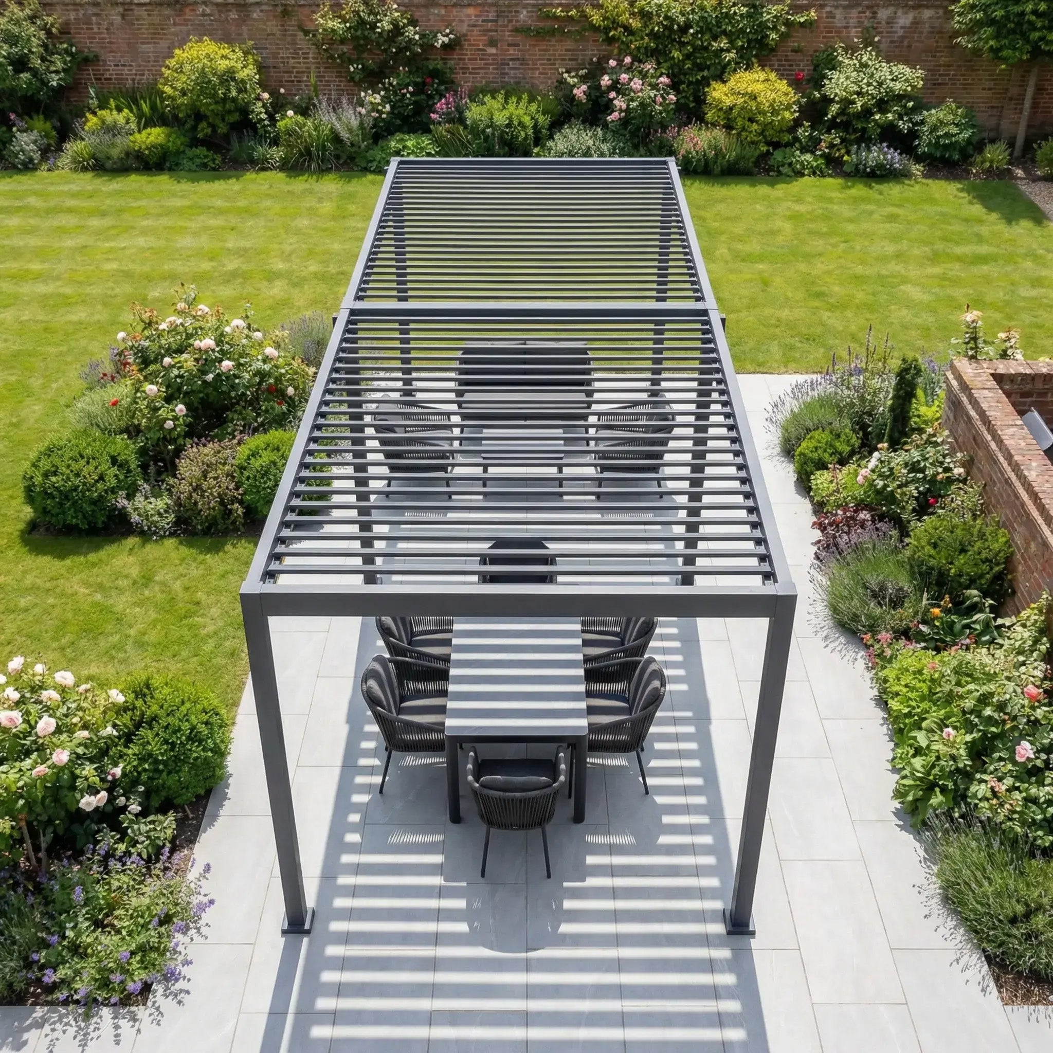 The PergoSTET Lite Neo 3m x 7m Metal Rectangular Pergola in Grey features adjustable louvres and provides stylish outdoor shade for your patio dining area, blending seamlessly into any landscaped garden.