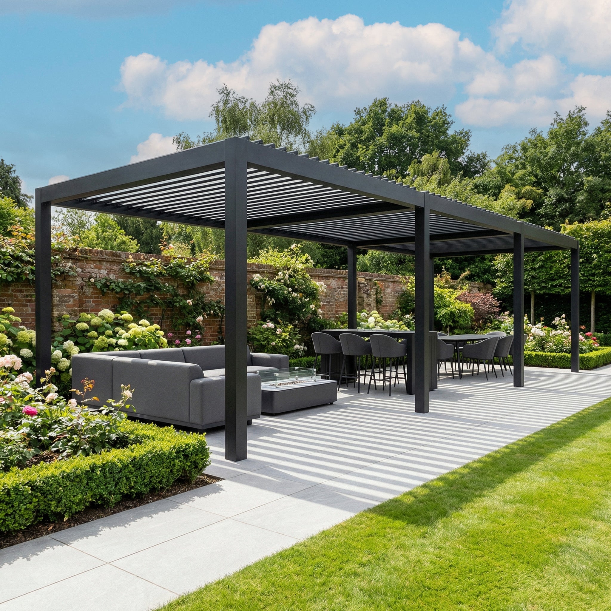 The PergoSTET Deluxe Frame Only 3m x 9m Rectangular Pergola with Motorised LED Louvres in Grey offers adjustable shade and style for dining or relaxing in a landscaped garden under a blue sky. Outdoor seating completes this modern gathering space.