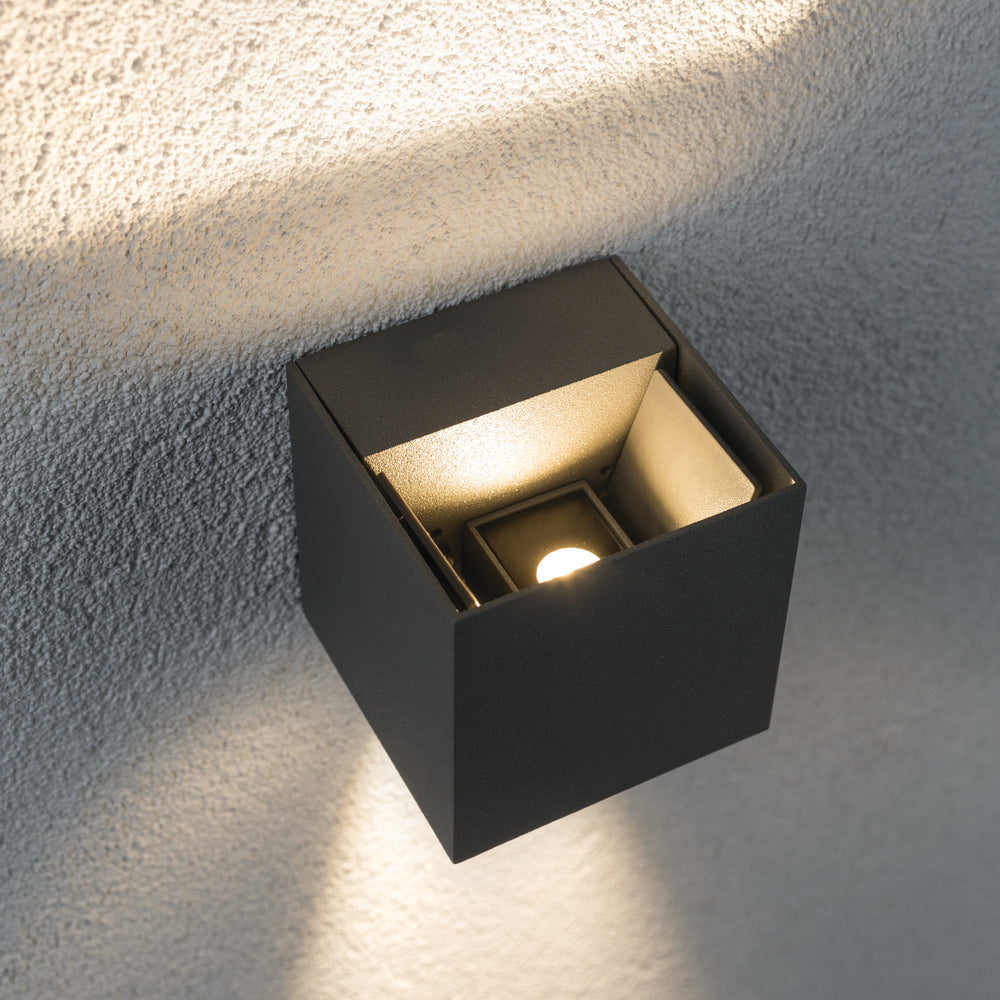 The Paulmann Outdoor Cybo 7.7W LED wall light in grey, featuring a cube shape and adjustable beam angle, transforms textured surfaces with stunning light effects.