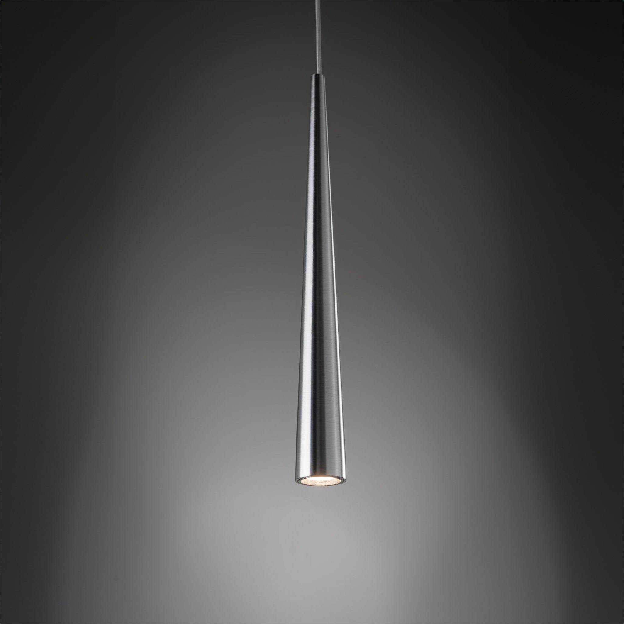 The Paulmann Gutta 8.5W LED pendant light, featuring a sleek brushed aluminum finish and adjustable cable, emits a soft glow from its conical shape against a dark background.