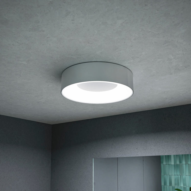 The Paulmann - Casca 18W LED Switch 1500lm Ceiling Light in Matt Aluminium brightens a modern room with grey walls and a touch of green tiles.