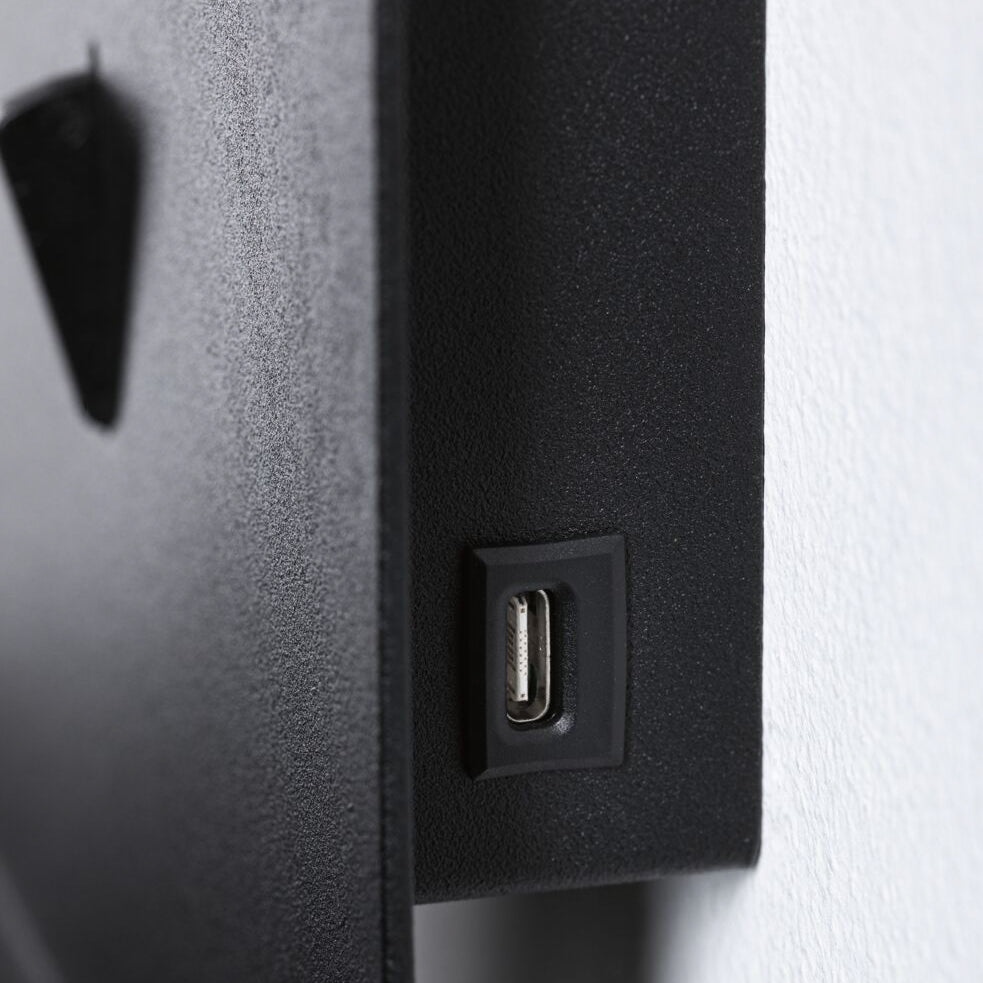 A close-up of the USB Type-C charging port on the Paulmann - Malena 5W Wall Light in black matt, seamlessly integrated into a wall-mounted luminaire against a white backdrop.