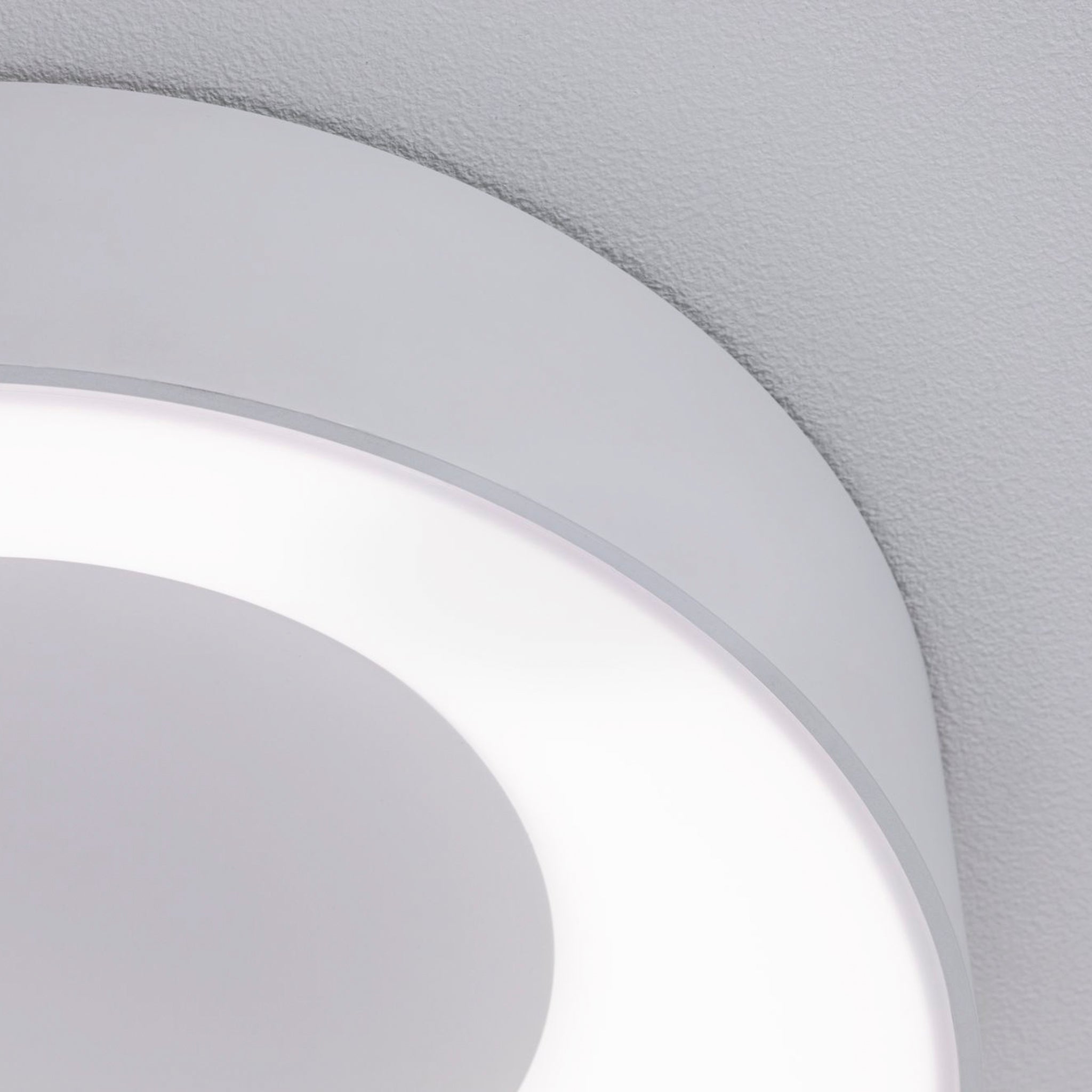 Close-up of the Paulmann - Casca 18W LED Switch 1500lm Ceiling Light in White, featuring soft white illumination and an elegant lighting effect against a light gray background.