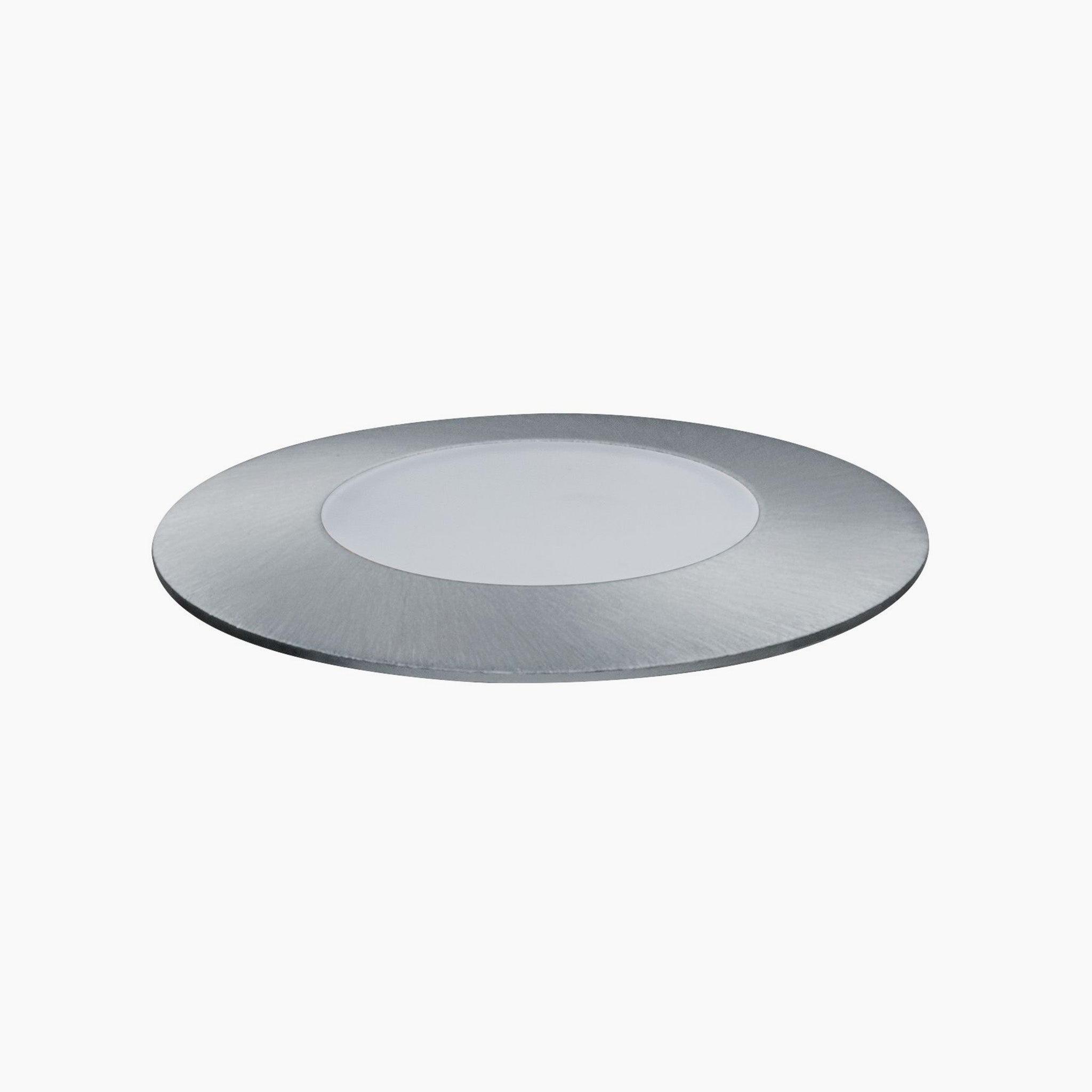 A round, flat, metallic disc with a brushed finish from the Paulmann Plug & Shine Outdoor 2.5W LED Floor Mini Individual Spotlight in Silver gleams elegantly against a plain background, reminiscent of sleek recessed spotlights in outdoor lighting setups.