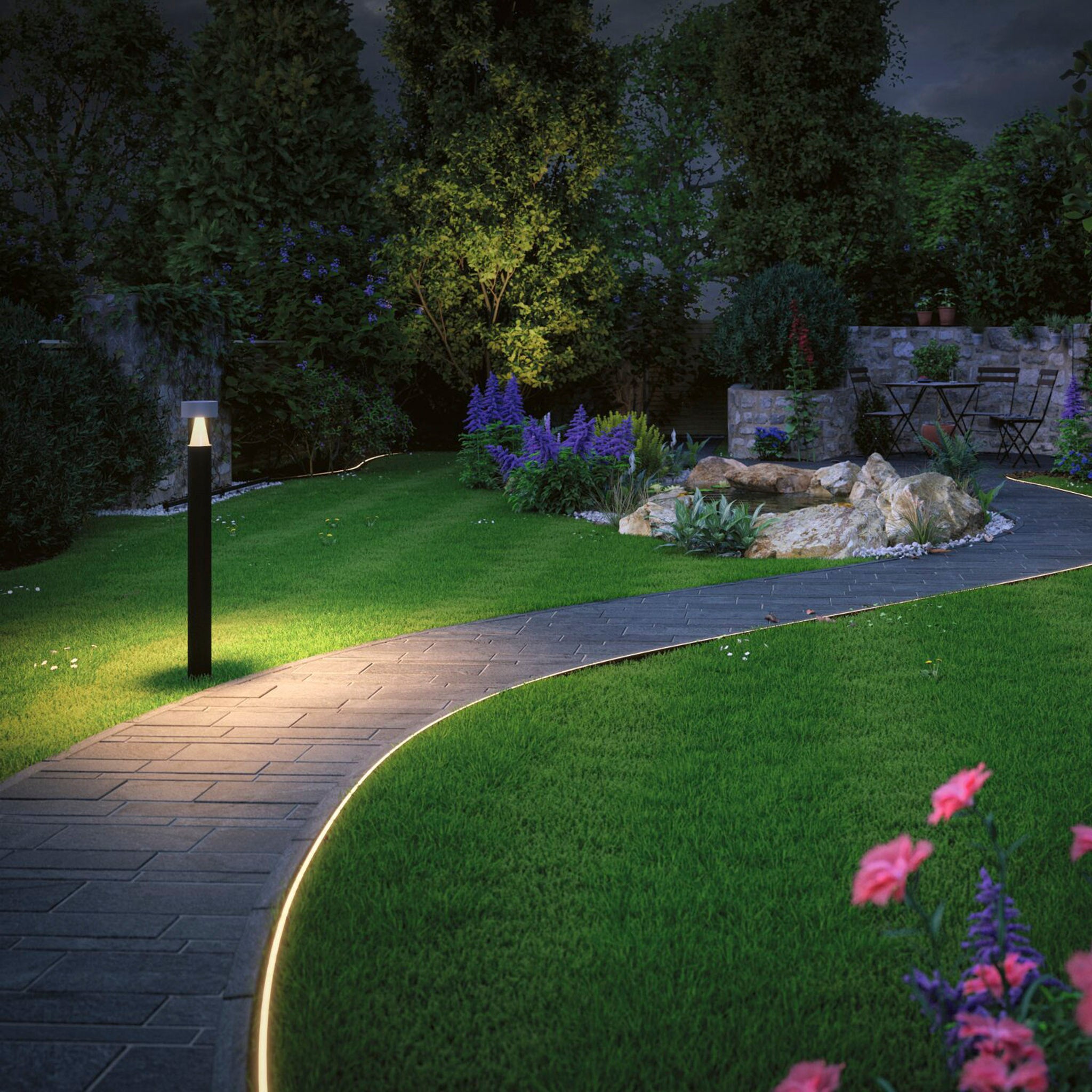 A nighttime garden features a glowing path illuminated by the Paulmann - Plug & Shine Outdoor 31W LED Light Strip in Warm White, complemented by blooming flowers and a stone-bordered pond encircled by lush greenery.