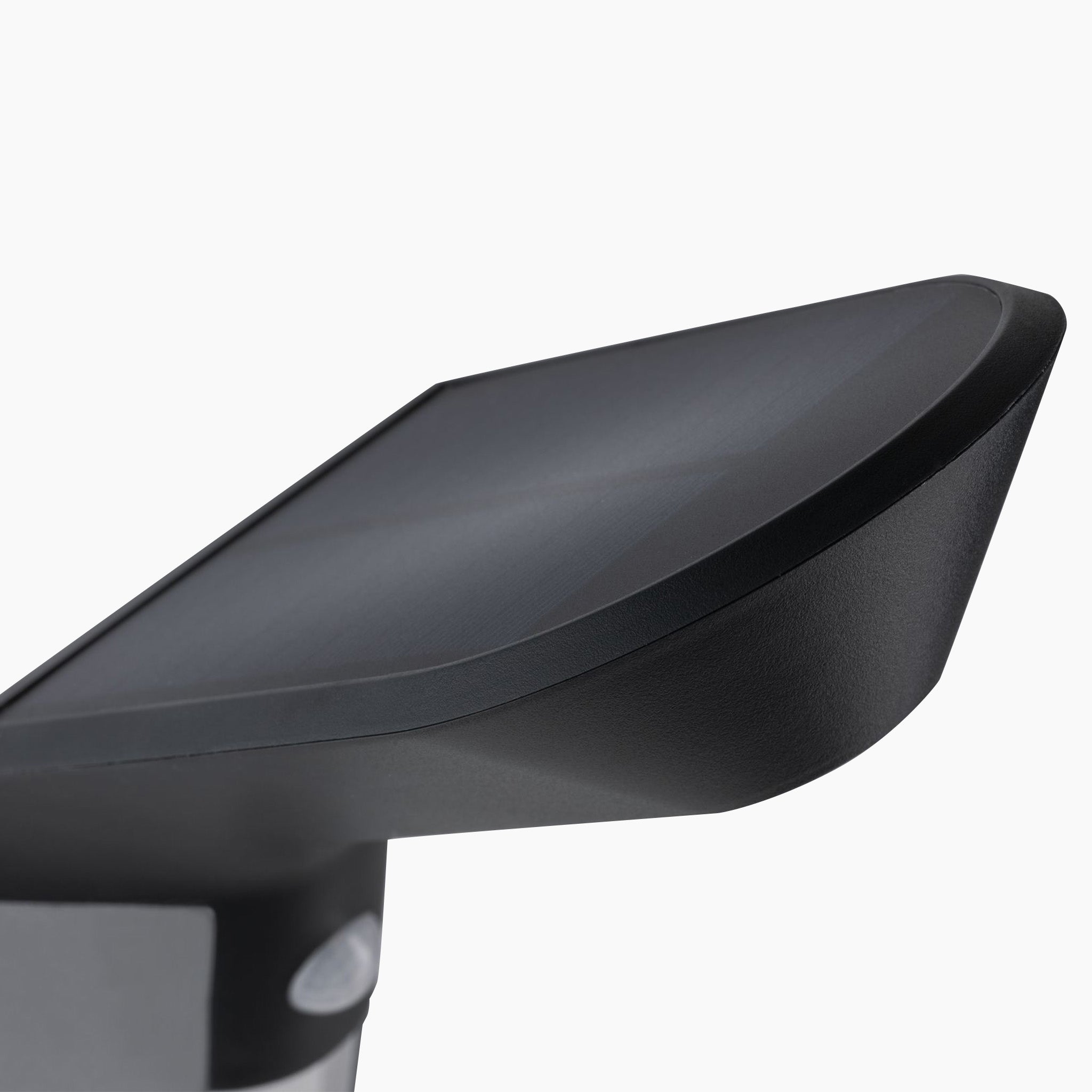 Close-up of a modern, sleek, anthracite object with a curved edge, resembling a monitor or screen, designed with solar technology for efficient battery recharges—Paulmann's Outdoor Soley 1.22W LED Bollard Lighting with Motion Detection.