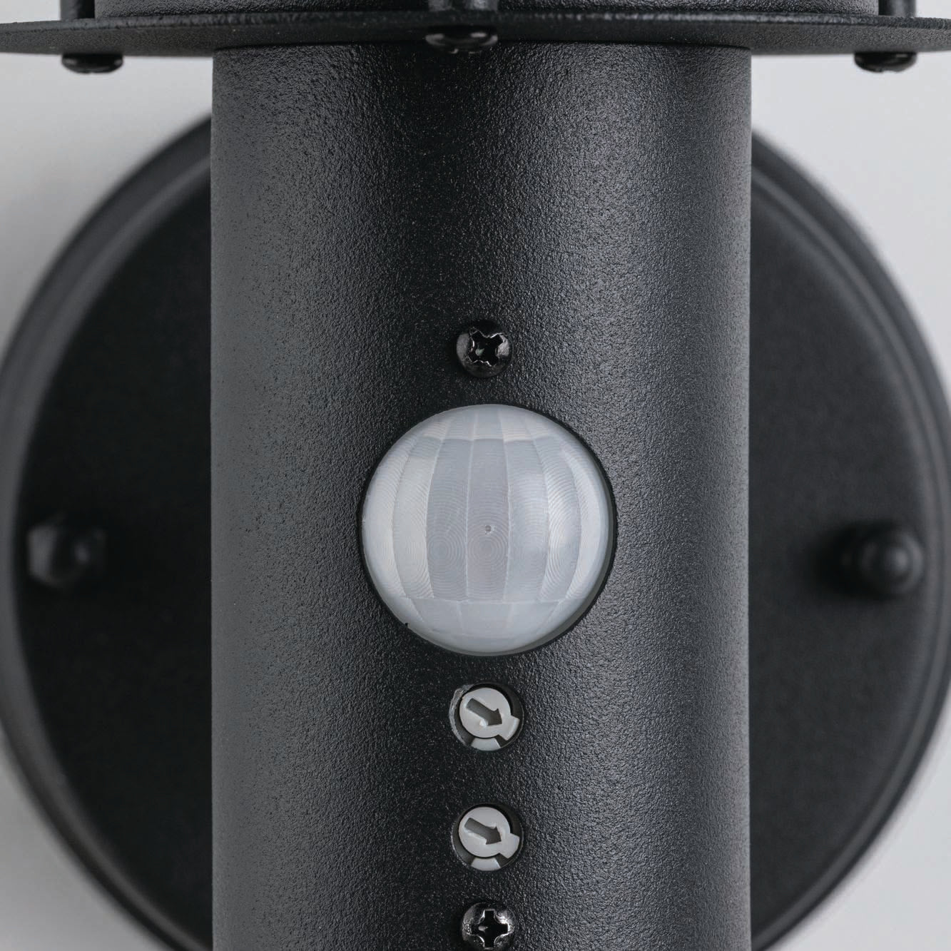 Close-up of the Paulmann - Outdoor Classic 15W LED Wall Light in dark grey, featuring a round sensor for motion detection, adjustable screws, and IP44 protection to withstand the elements.