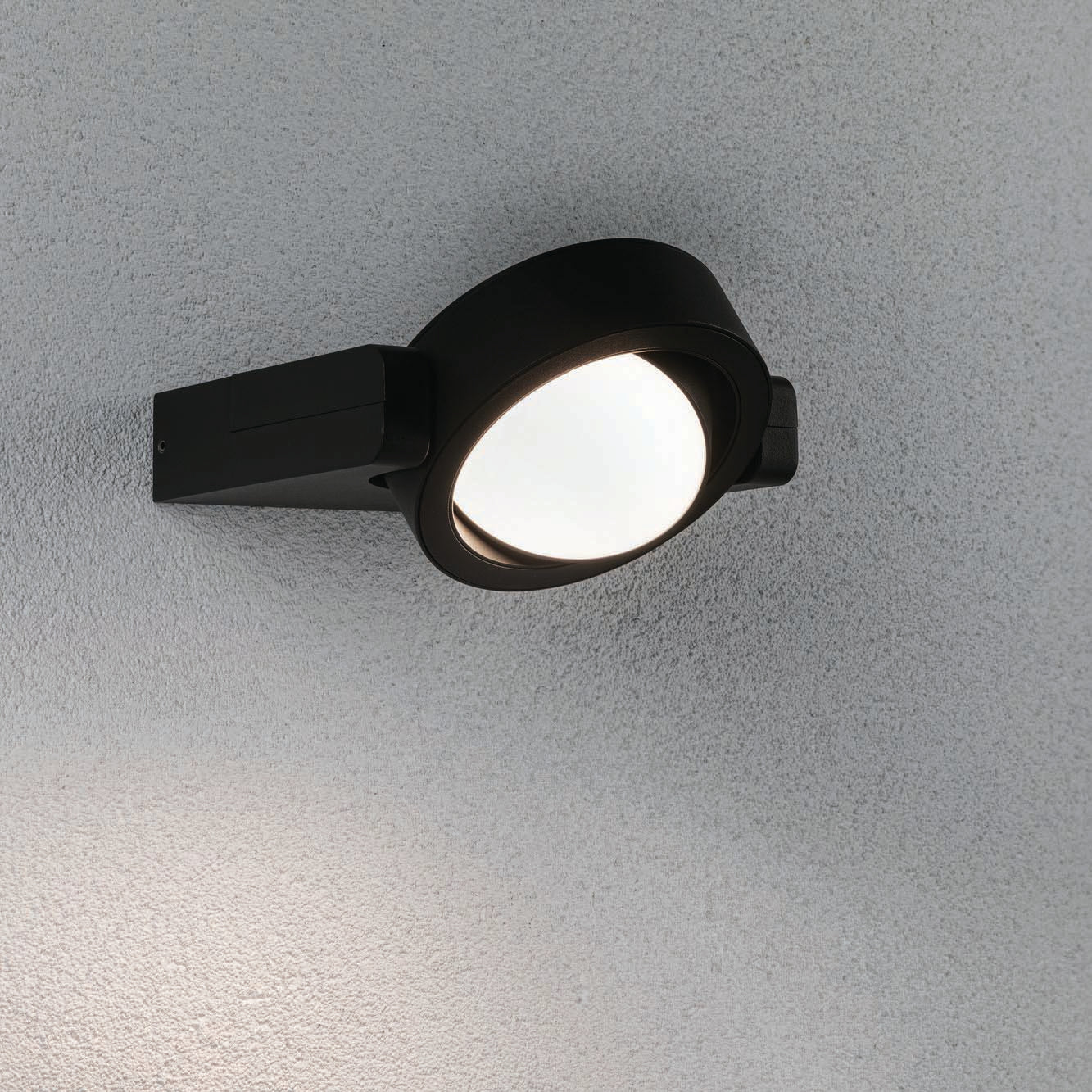 Paulmann's Outdoor Swivea 8W LED Wall Light in Anthracite, wall-mounted on a textured gray exterior surface, features cardanic swiveling for optimal lighting.