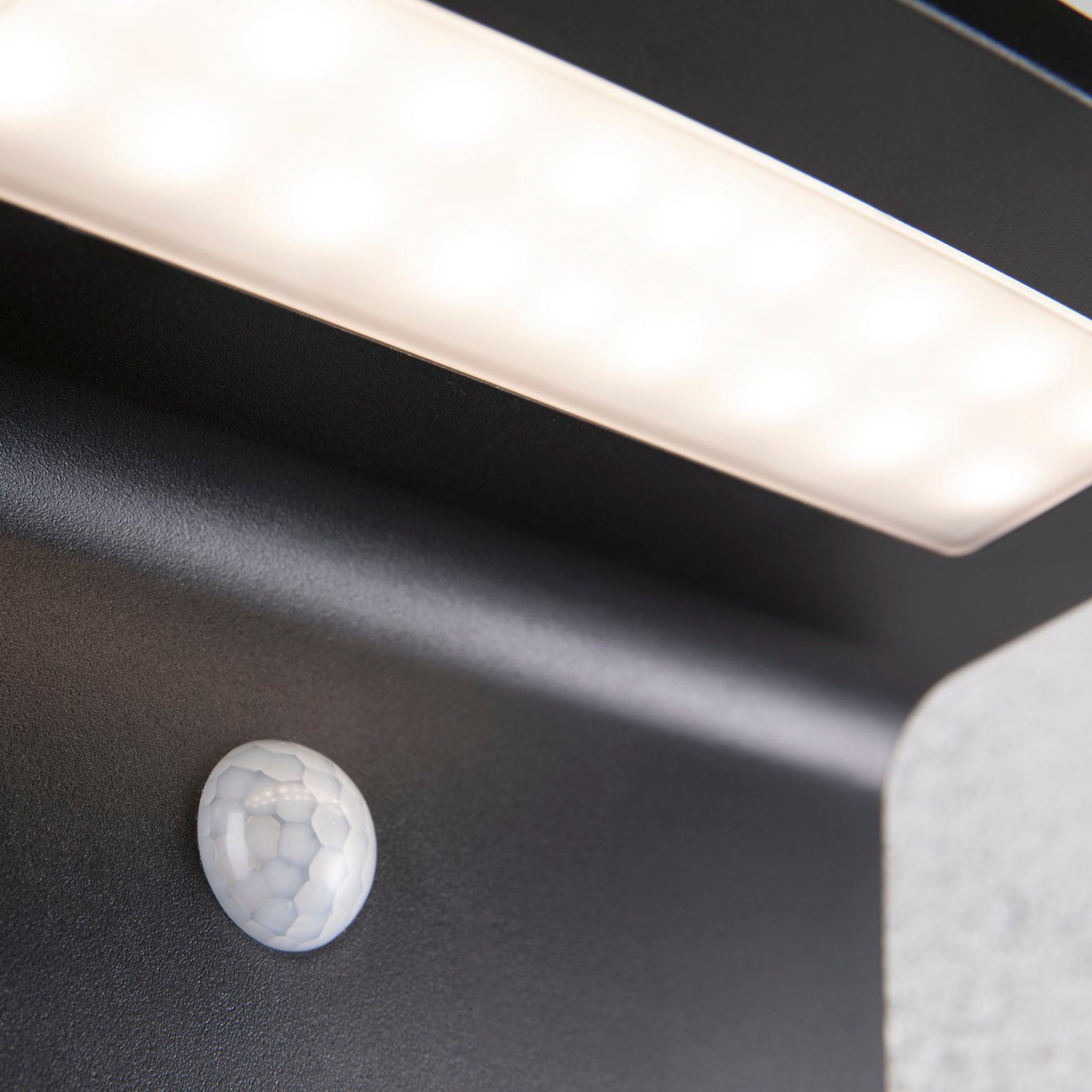 Close-up of the Paulmann Outdoor Cyrus 5W LED solar wall orientation light with motion detection, presented on a sleek anthracite base, perfect for illuminating exterior walls and featuring IP44 protection.