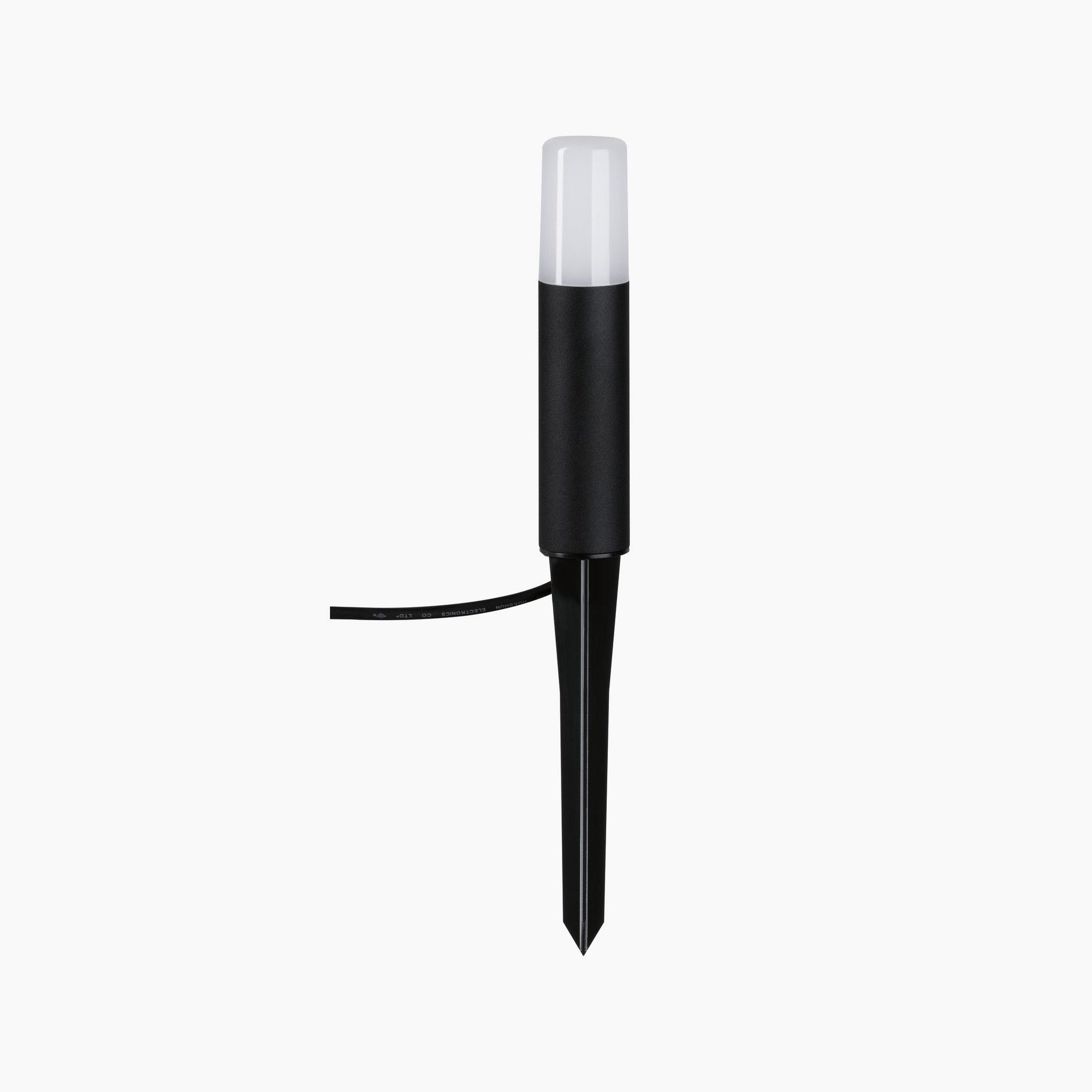 The Paulmann - Plug & Shine Outdoor Flarea 3.6W LED Single Bollard Light in Black Metal features a white cylindrical top with a pointed stake, offering glare-free lighting to enhance ambiance. This 20cm light is designed with IP65 protection for durability against the elements.
