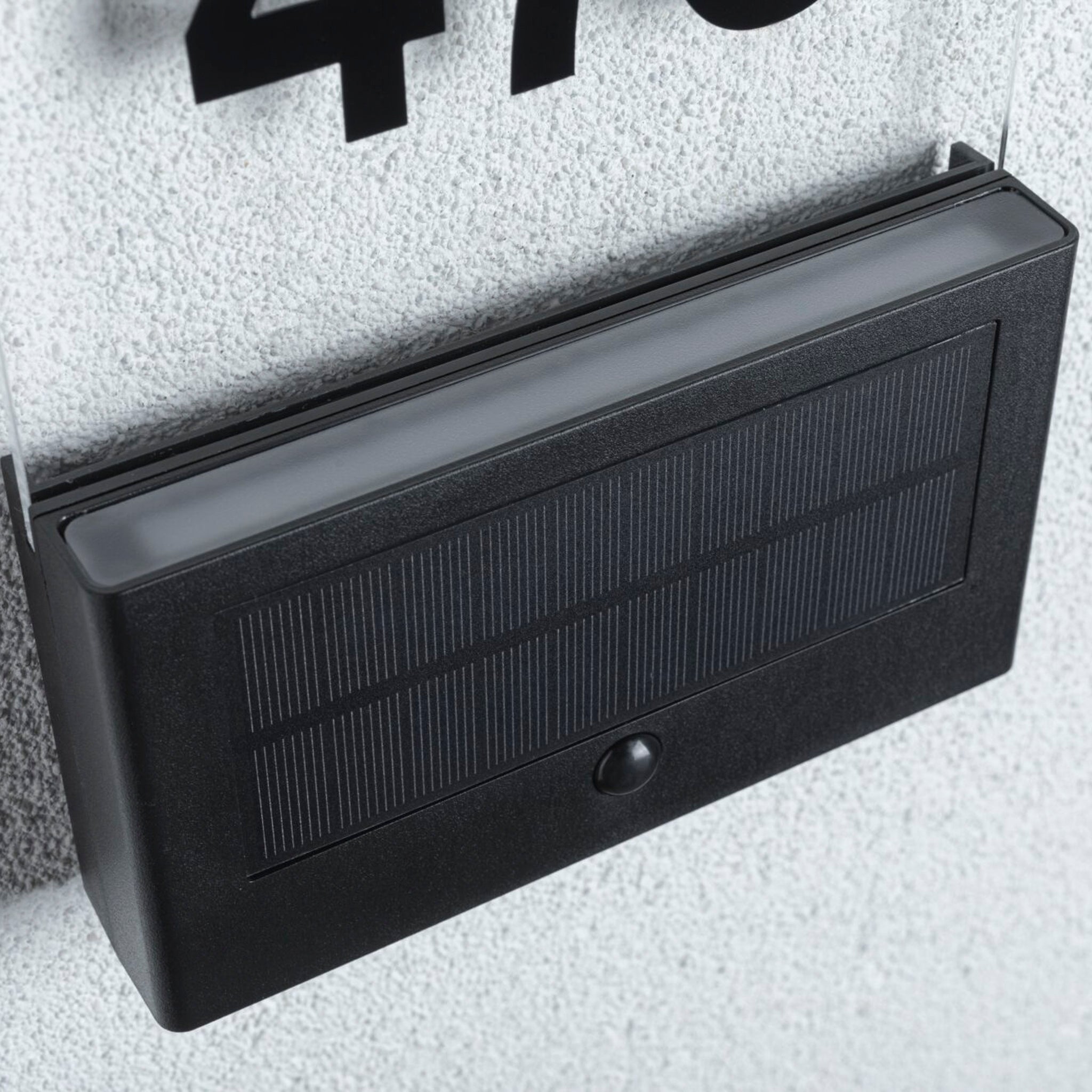 Close-up of the Paulmann Outdoor Neda Solar House Number 1W LED, anthracite, with motion detection, set against a textured surface background and featuring an integrated dusk sensor for optimal performance.