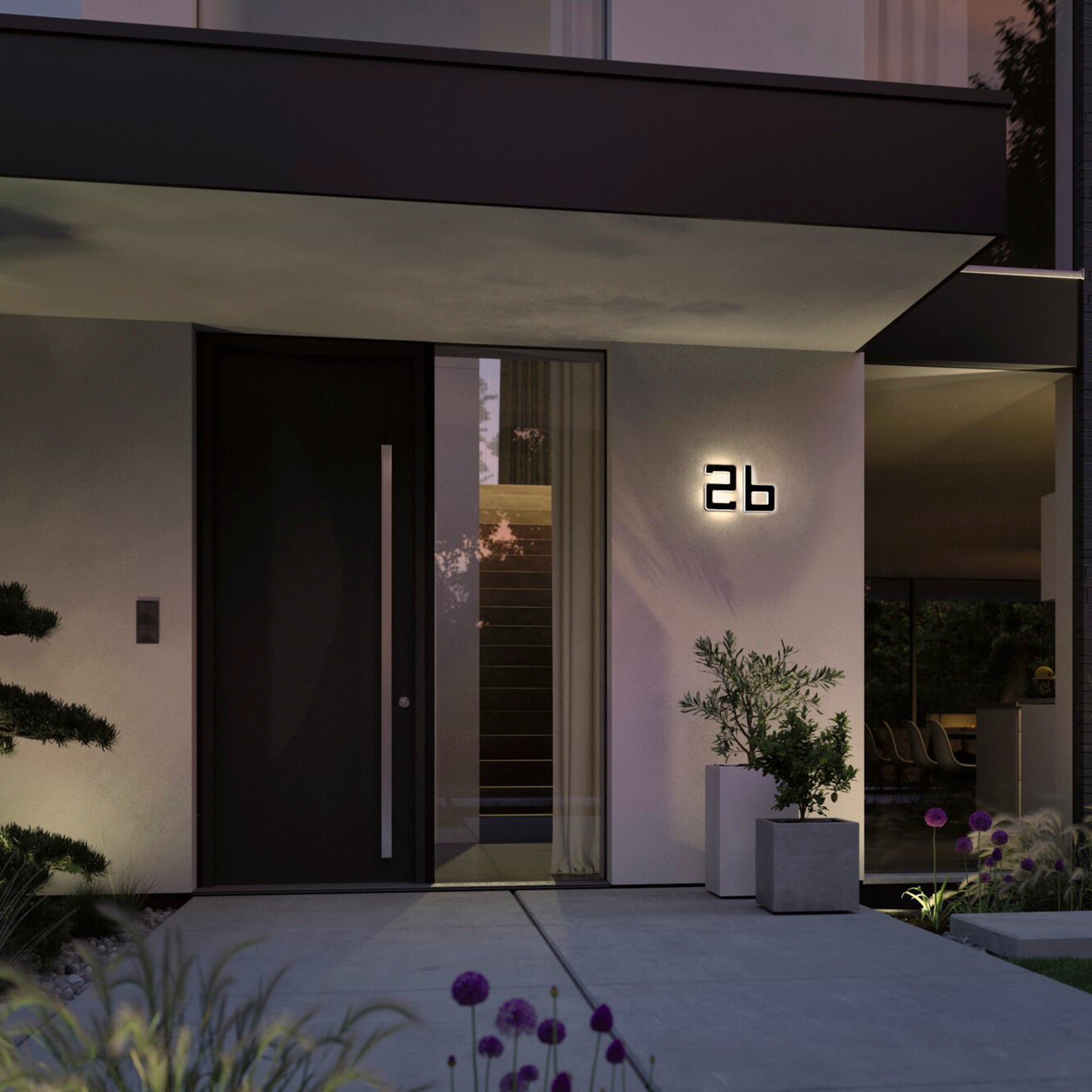 The modern house entrance showcases a solar-powered Paulmann luminaire, emphasizing the decorative letter "B" and is complemented by a large black door, potted plants, and a charming pathway.